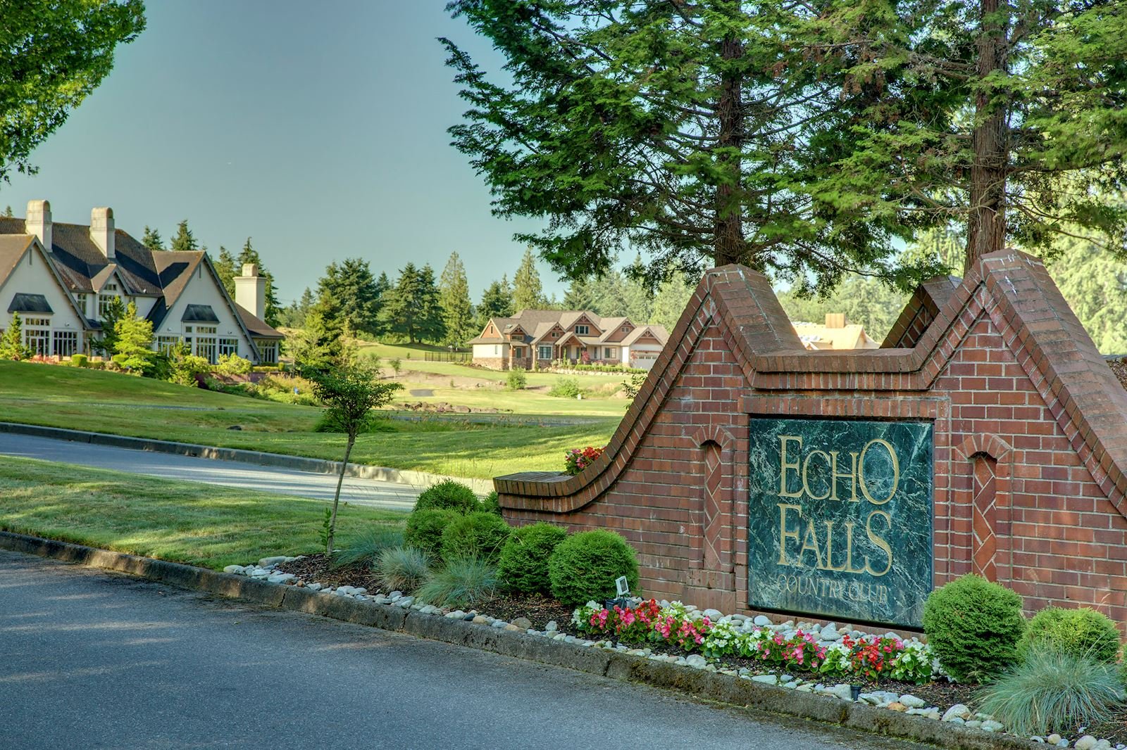 Echo Falls Country Club entrance sign with brick monument, manicured landscaping, and luxury homes along the golf course fairway — Snoqualmie, Washington