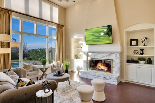 Spacious family room with floor-to-ceiling fireplace and oversized windows in Clyde Hill home
