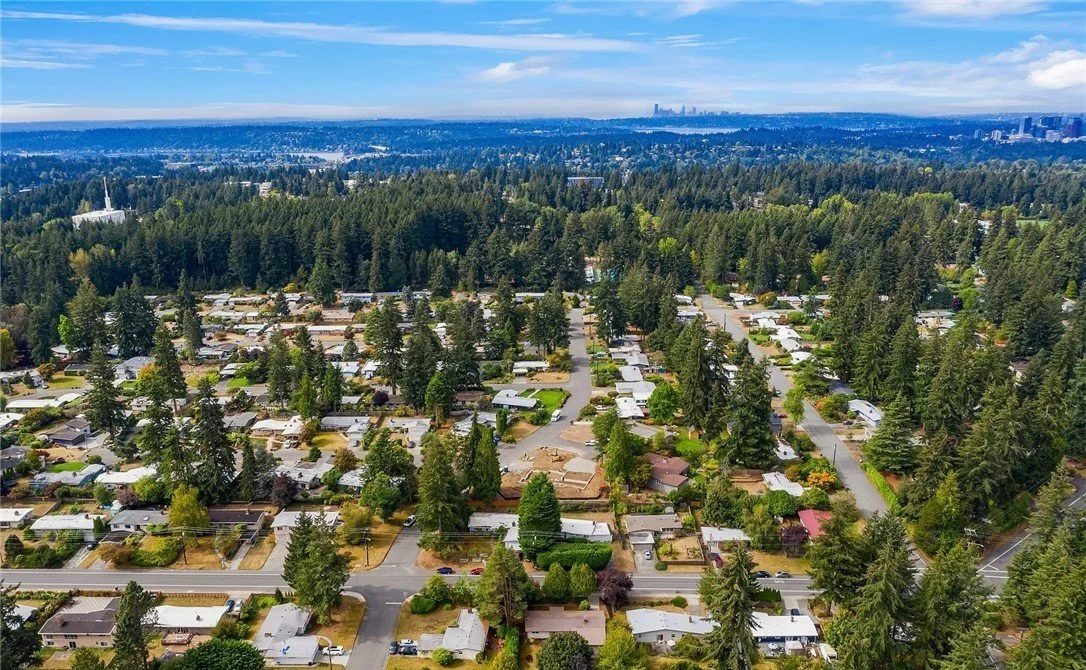 Aerial view of Southeast Bellevue residential neighborhoods including Woodridge and Lake Hills, showing tree-canopied streets and single-family homes in the Bellevue School District