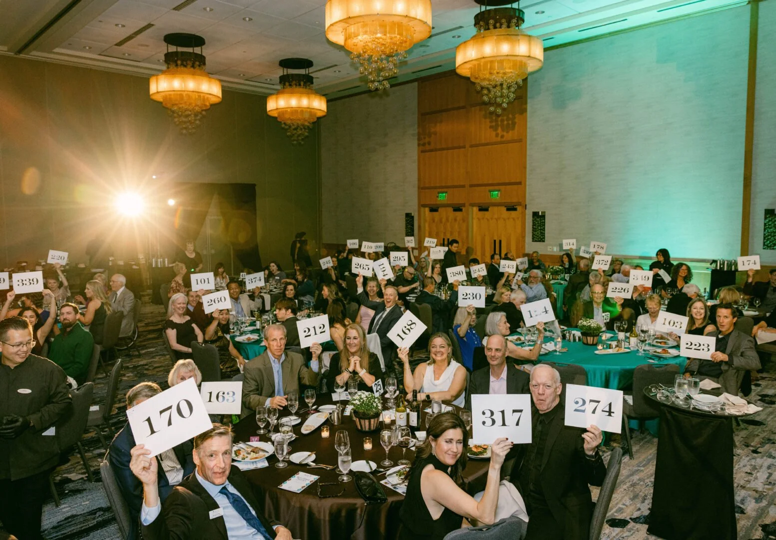 Guests raising paddle numbers during the Acres of Diamonds 2026 Diamond Dinner live auction