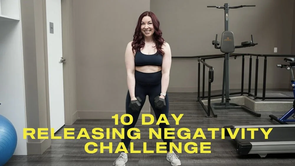 Title card for the 10 Day Releasing Negativity Challenge. Yellow text "10 Day Releasing Negativity Challenge" on a background of a woman in navy sport top and leggings holding dumbbells.