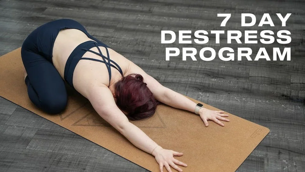 Title card for the 7 Day Destress Program. White text "7 Day Destress Program" on a background of a woman doing the yoga child's pose.