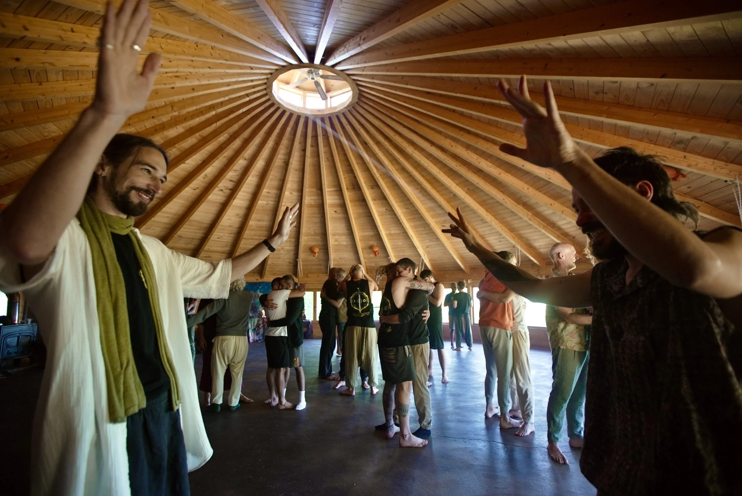 People practicing yoga or meditation in a spacious wooden-domed studio with high ceilings.