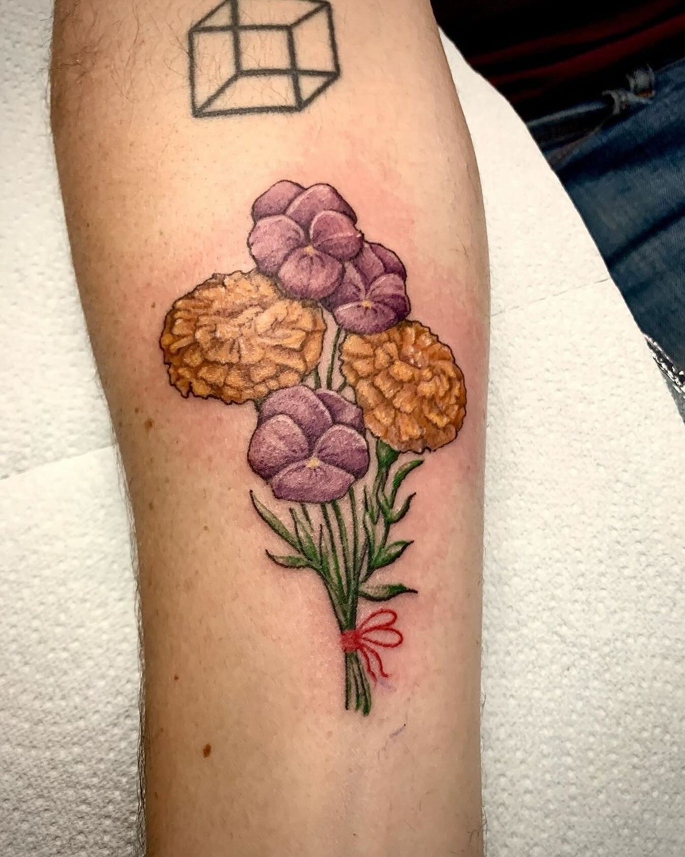 @charlieleightattoostuff Adorable lil bundle of flowers to represent their daughters 🤩 I love how sweet pieces like this are 🥰  #flowertattoo #floraltattoo #marigolds #marigoldtattoo #violet #violettattoo #colourtattoo #familytattoo #colourrealism 