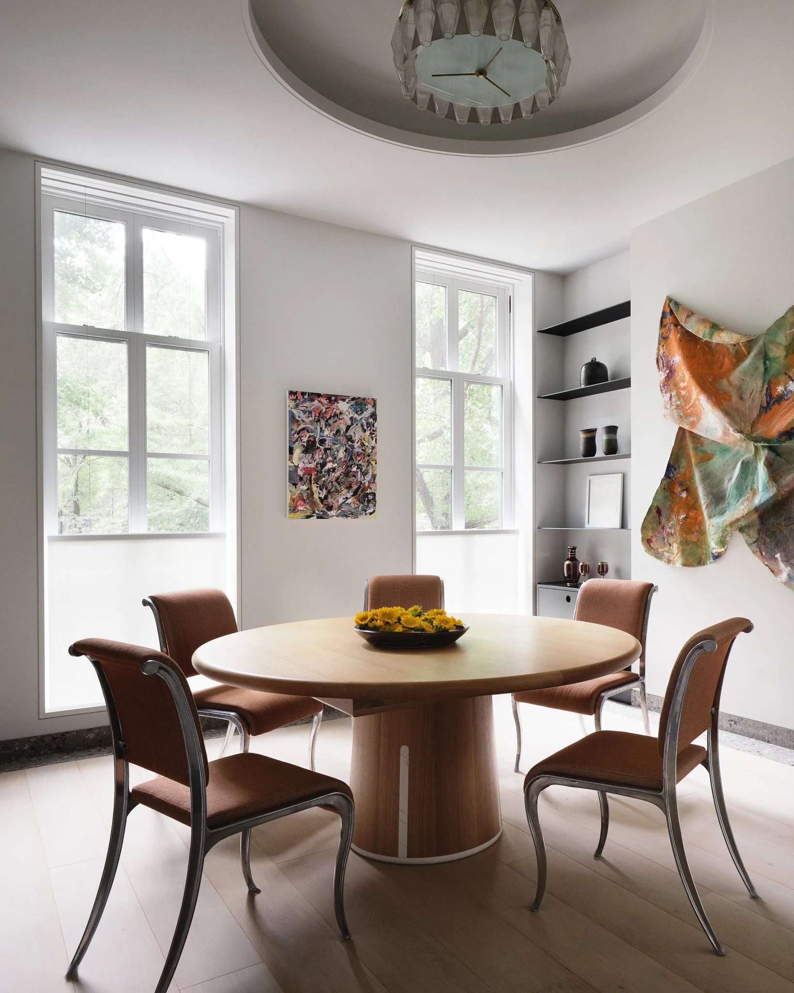 Dining room with a round oak table and vintage chrome chairs in a West Village townhouse by JG Neukomm Architecture
