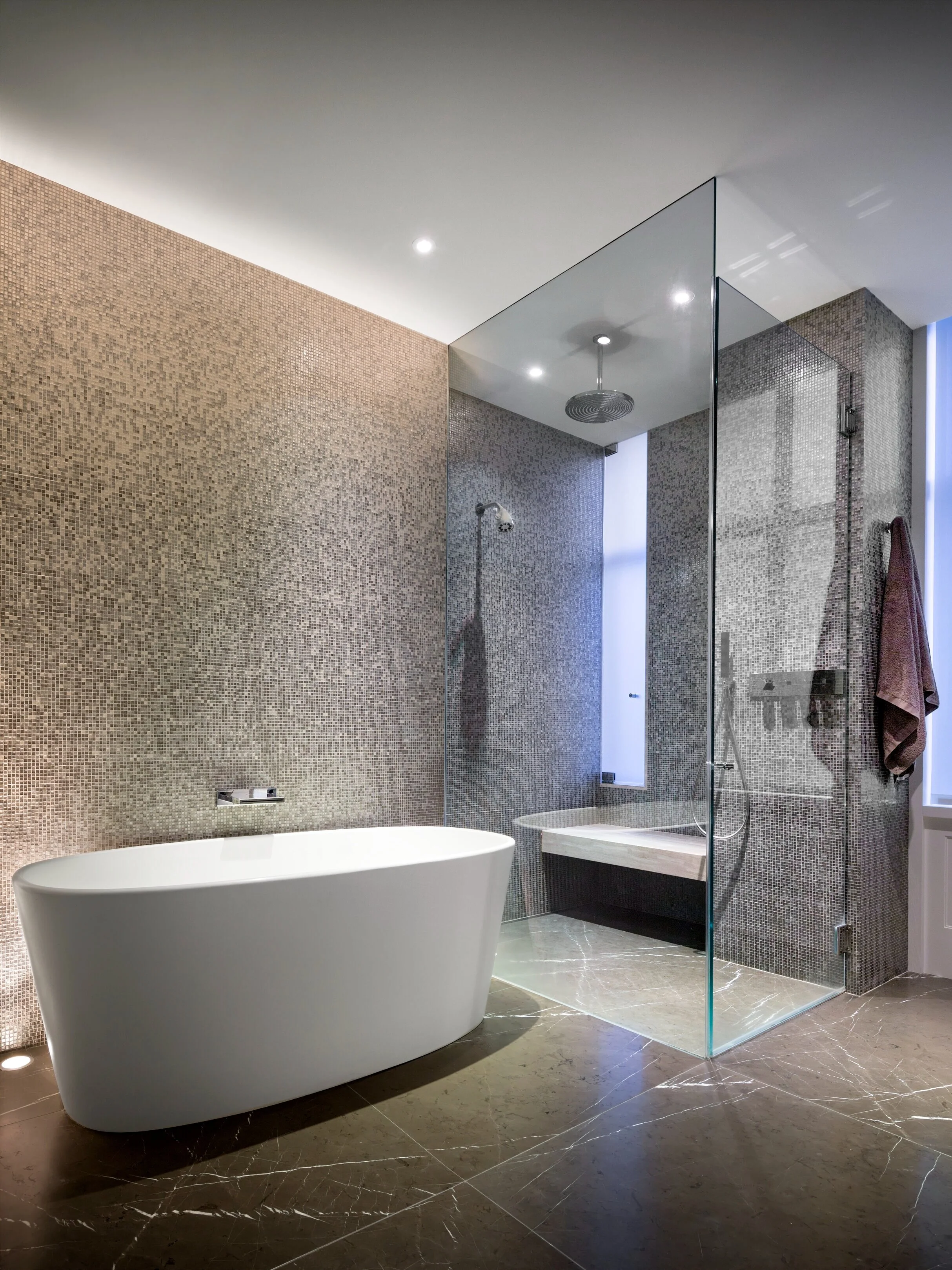 JGNA residence primary bathroom with a freestanding tub, mosaic tile walls, and a glass walk-in shower