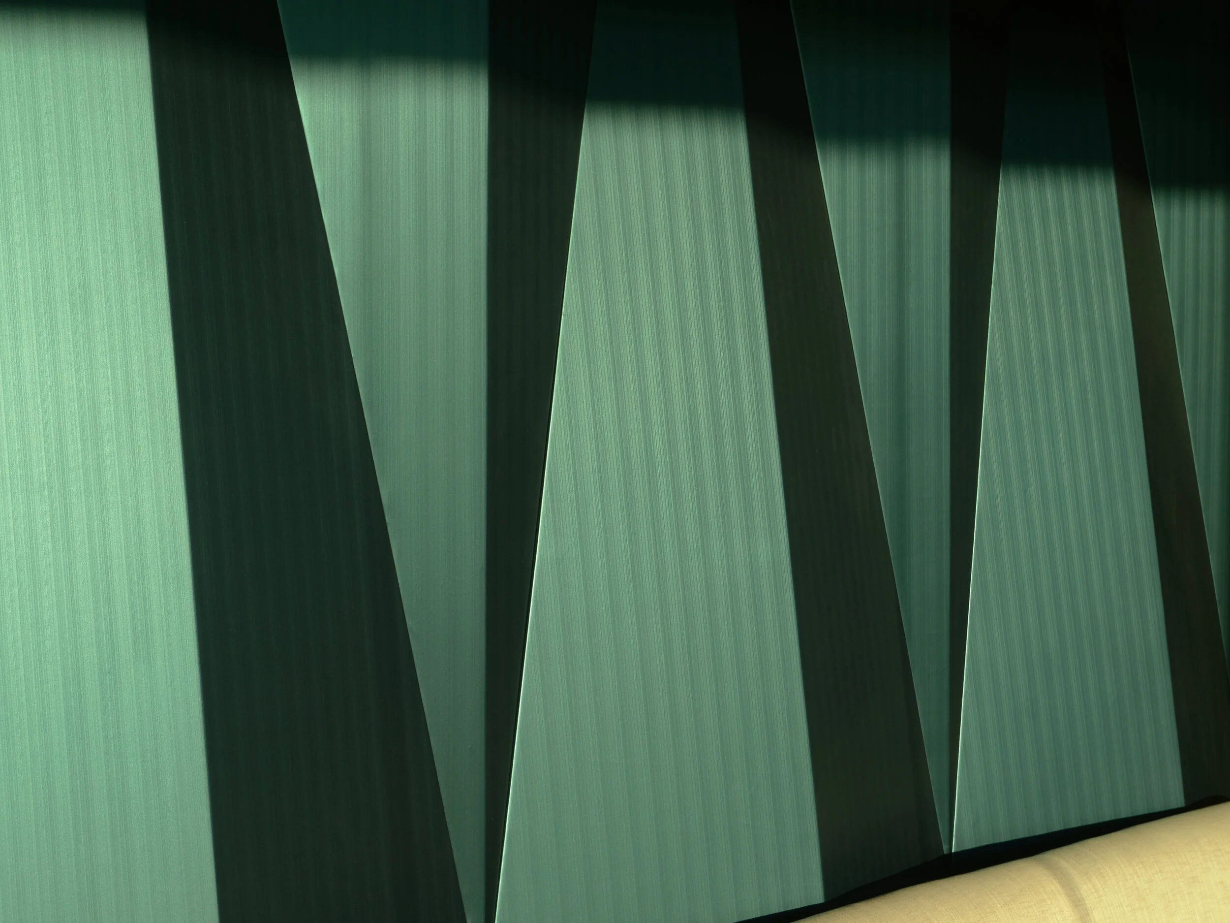 JGNA interior detail of faceted green glass wall panels catching angled light