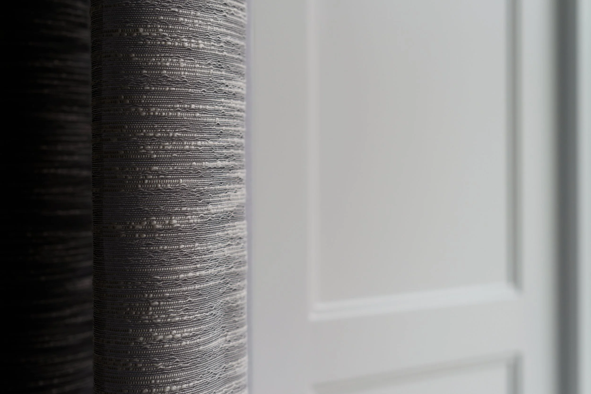 JGNA residence detail of textured grey wallcovering meeting a white paneled door edge