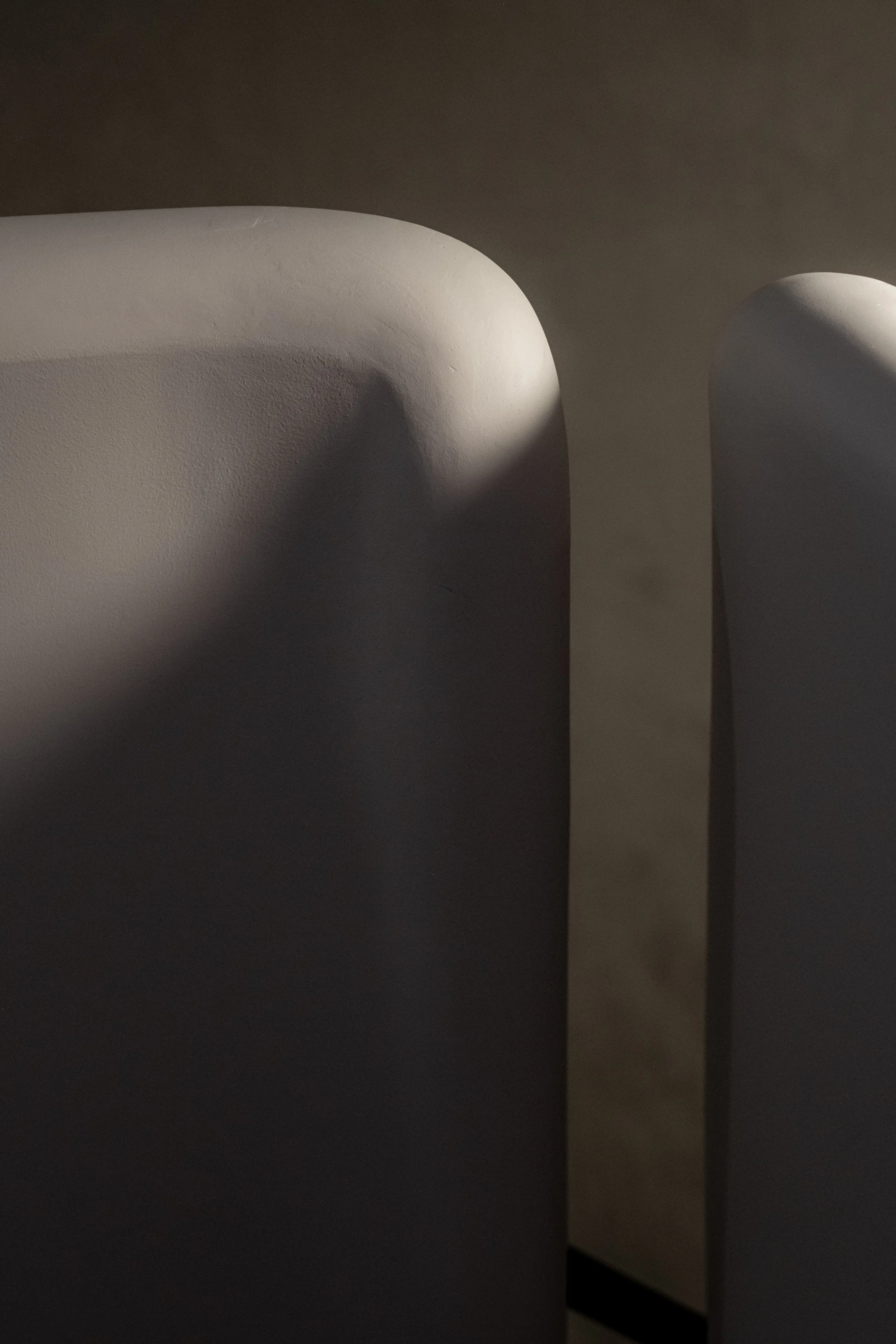 JGNA residential stair detail of softly lit curved plaster walls