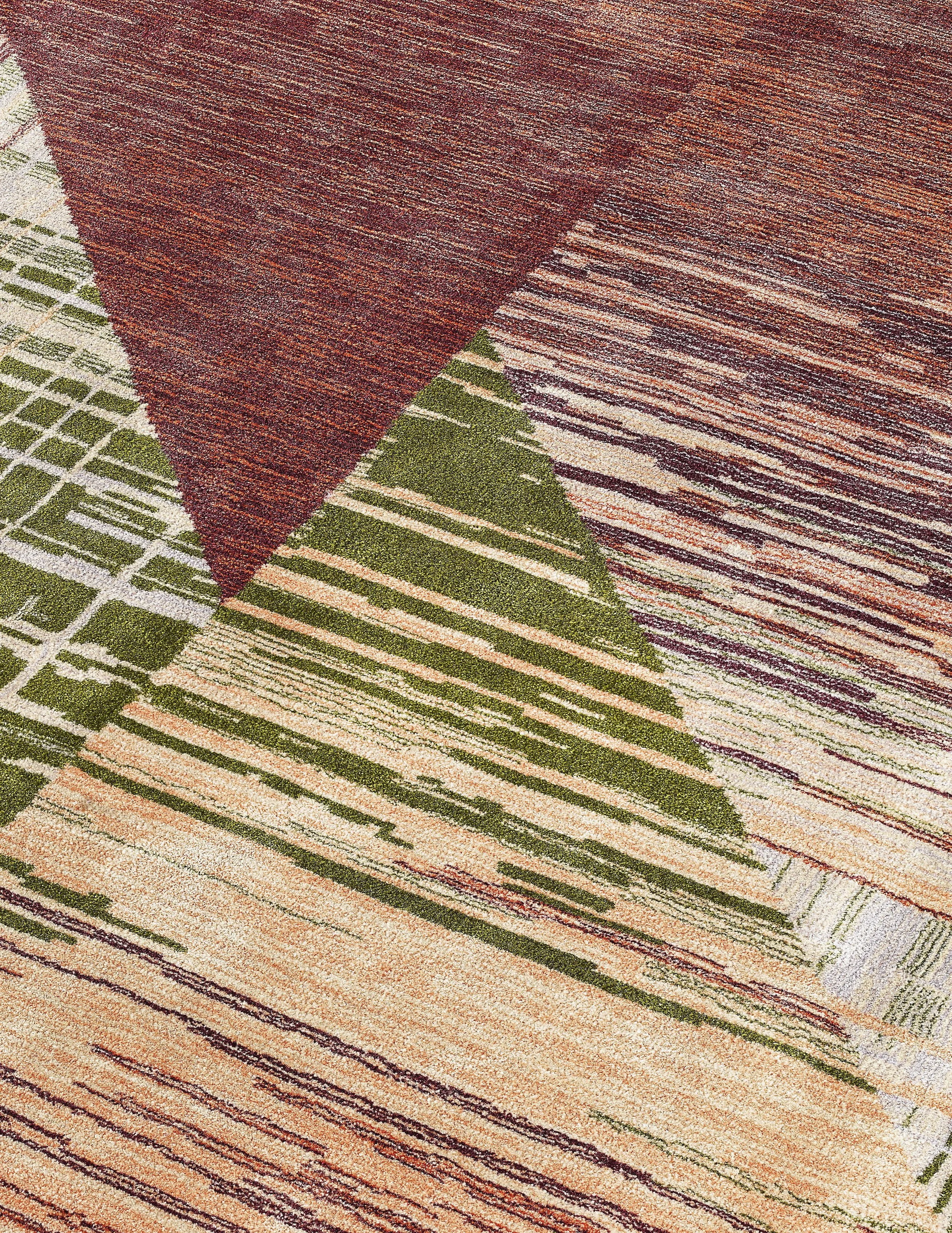 JGNA residential detail of a hand-tufted rug with a triangular motif in red, green, and coral