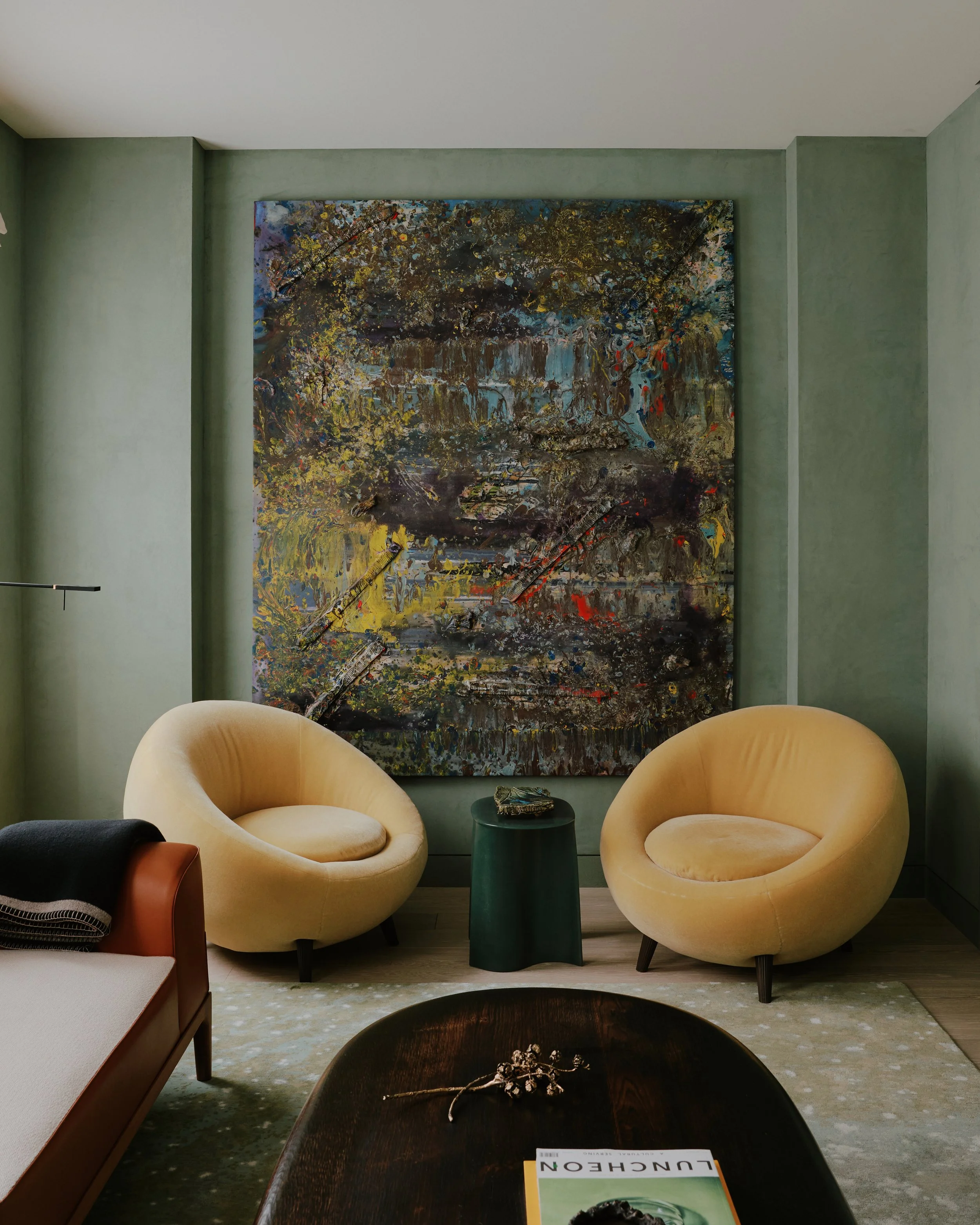 Sitting room with a pair of yellow lounge chairs and a large abstract painting in a West Village townhouse by JG Neukomm Architecture