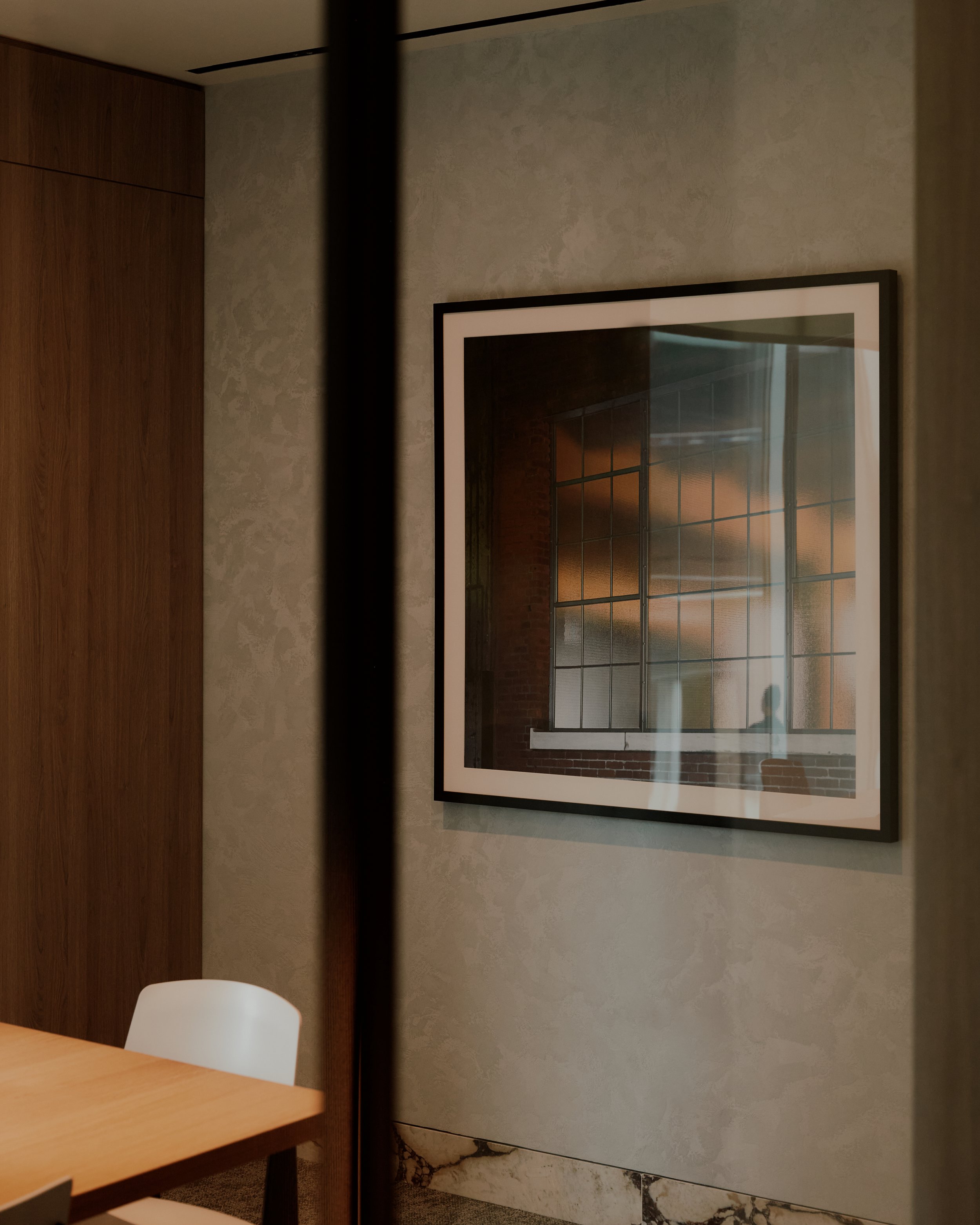 Framed artwork and refined material detailing in a private dining and gathering space at The Suffolk, a Lower East Side residential building, interiors by JG Neukomm Architecture