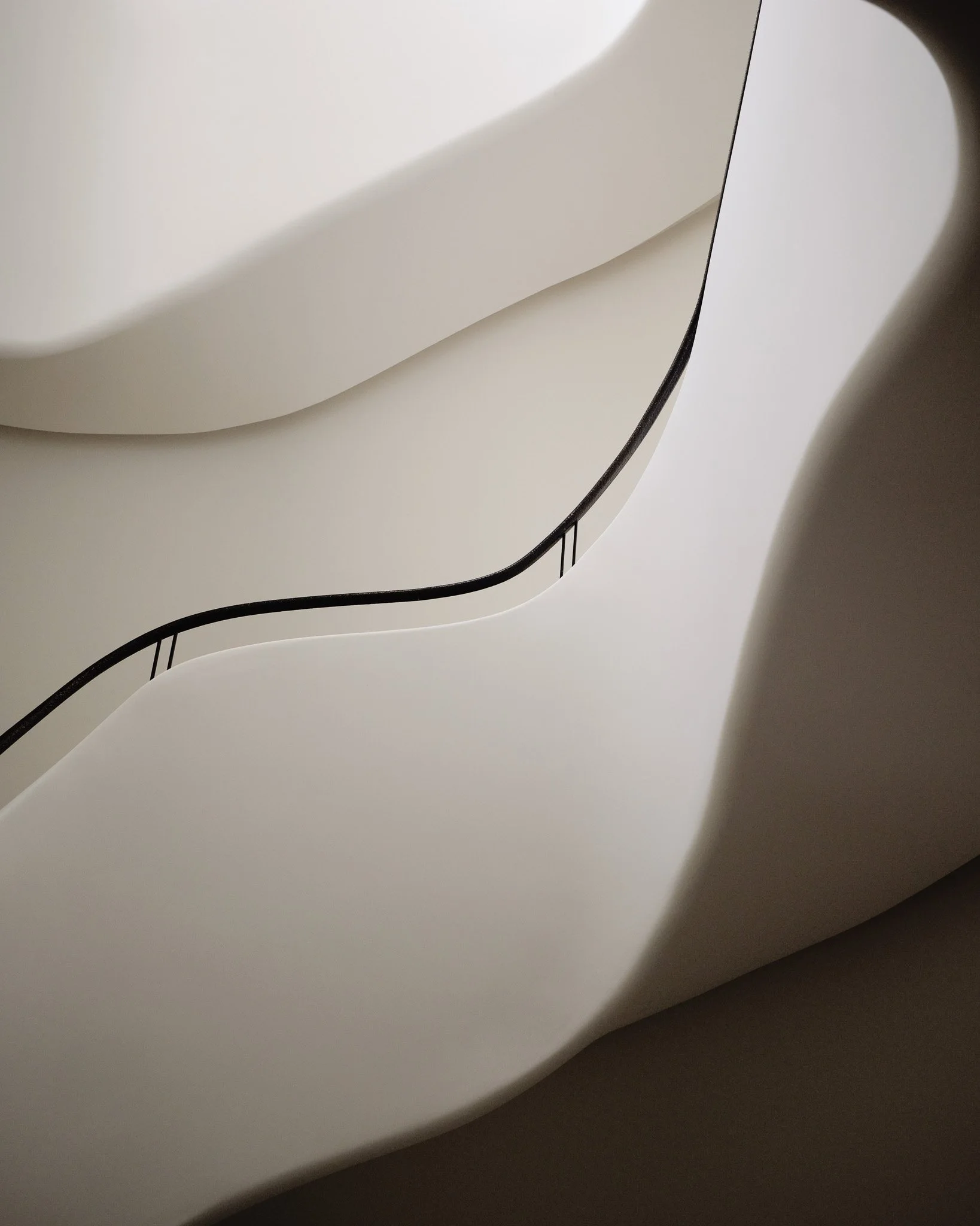 Sculptural plaster curves and a black handrail detail in a West Village townhouse by JG Neukomm Architecture
