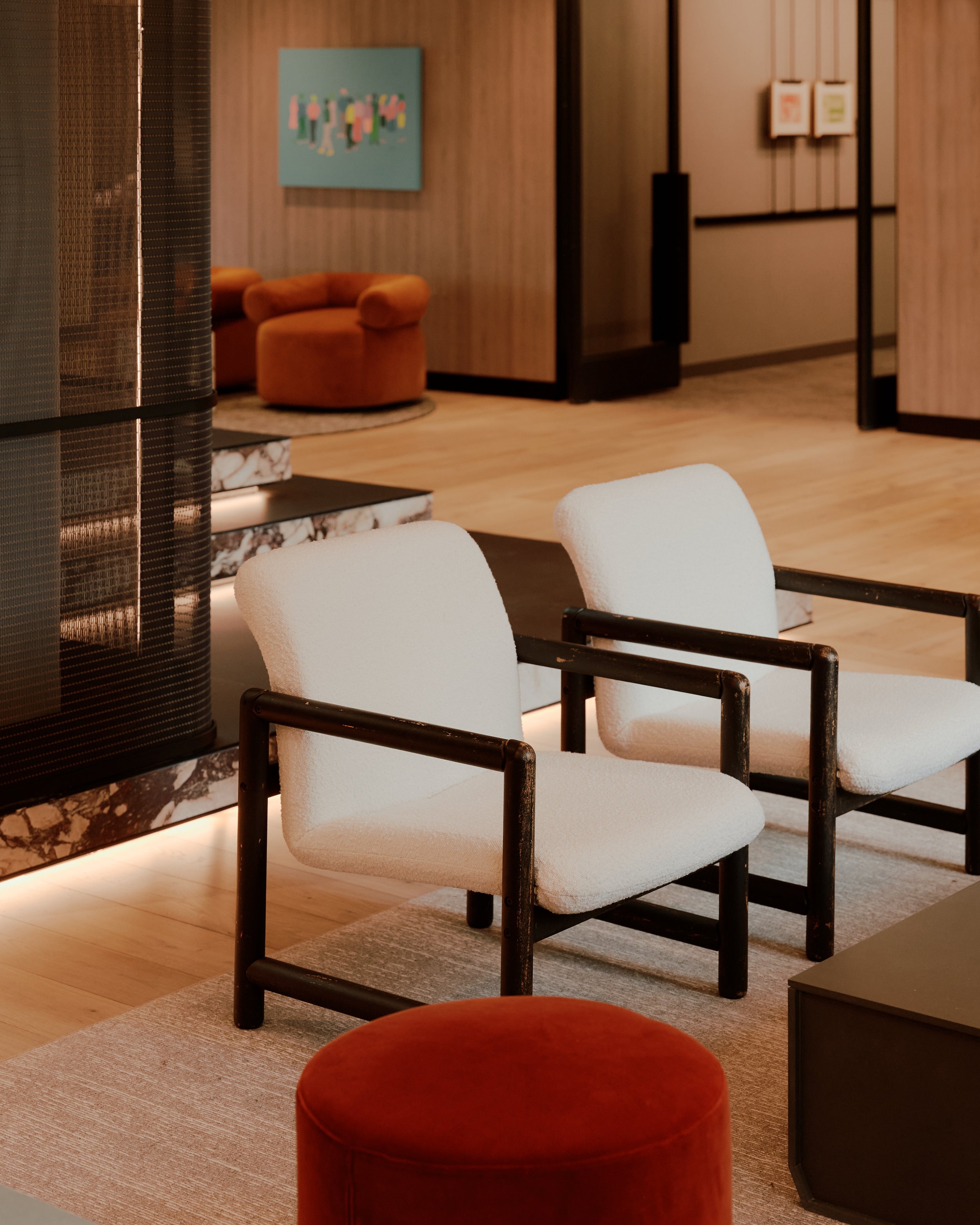 Custom lounge furniture and material detailing adjacent to the grand staircase at The Suffolk, a Lower East Side residential building, interiors by JG Neukomm Architecture