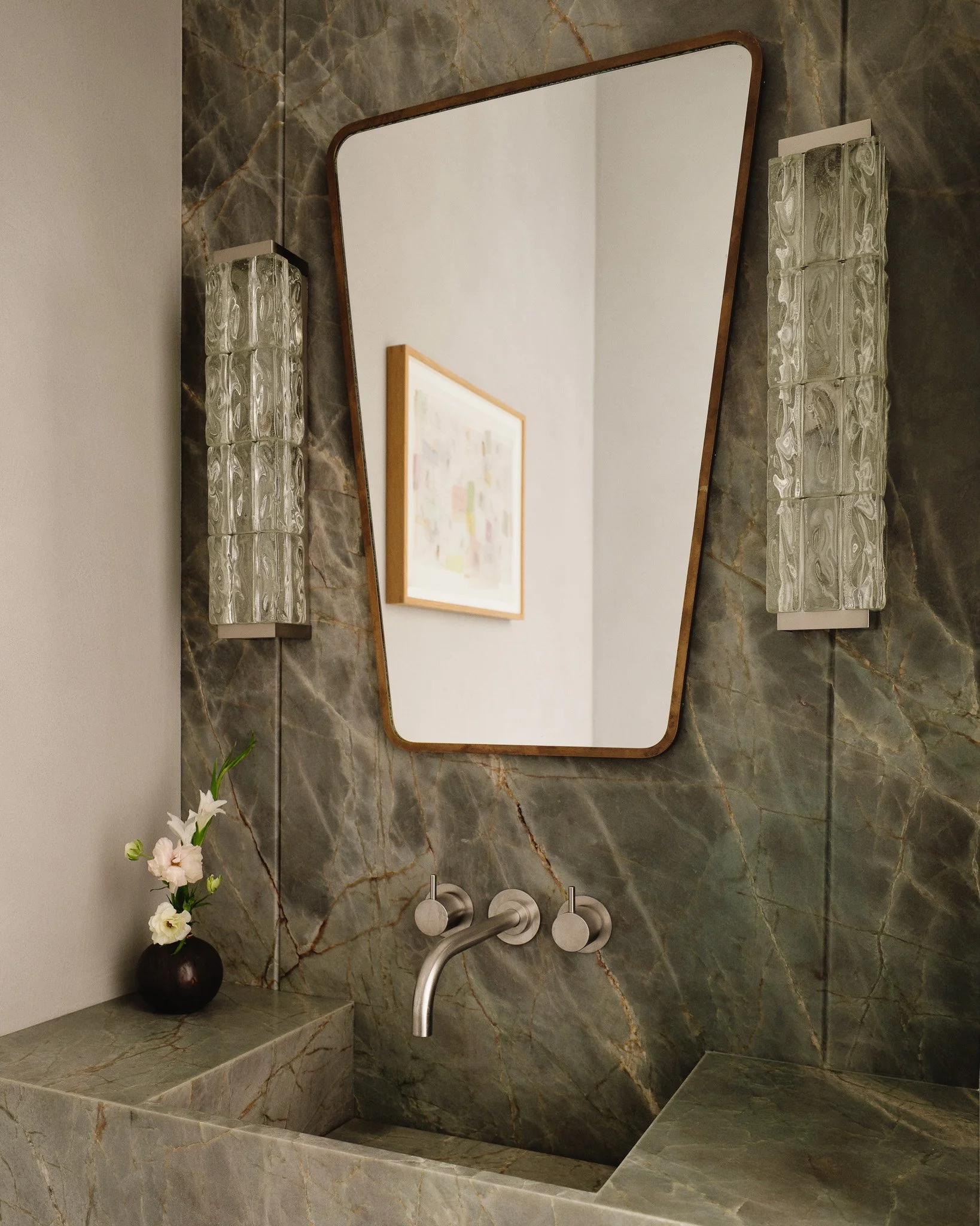 Powder room with green marble walls and an integrated stone sink in a West Village townhouse by JG Neukomm Architecture