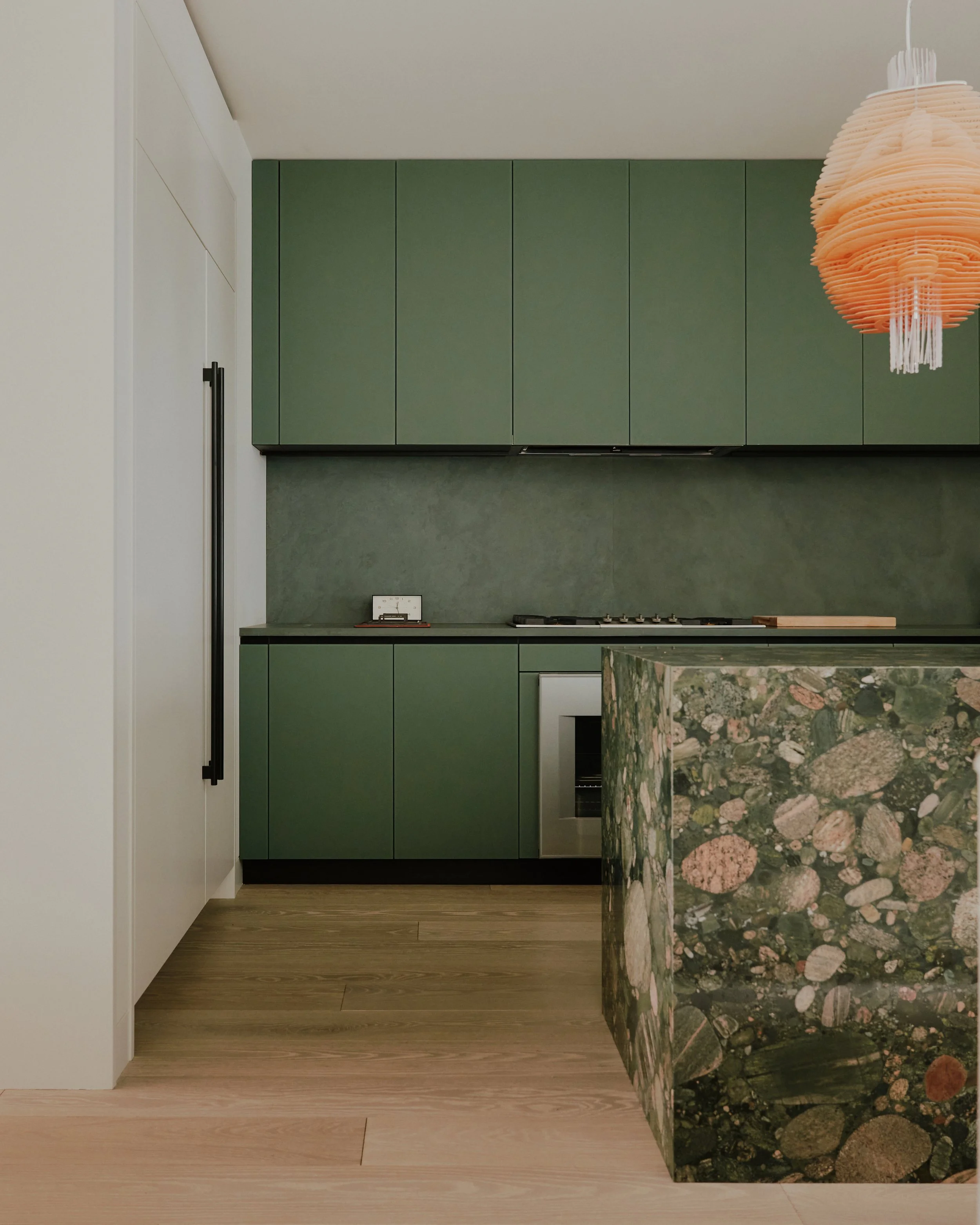 Kitchen island in conglomerate stone with bar seating in a West Village townhouse by JG Neukomm Architecture