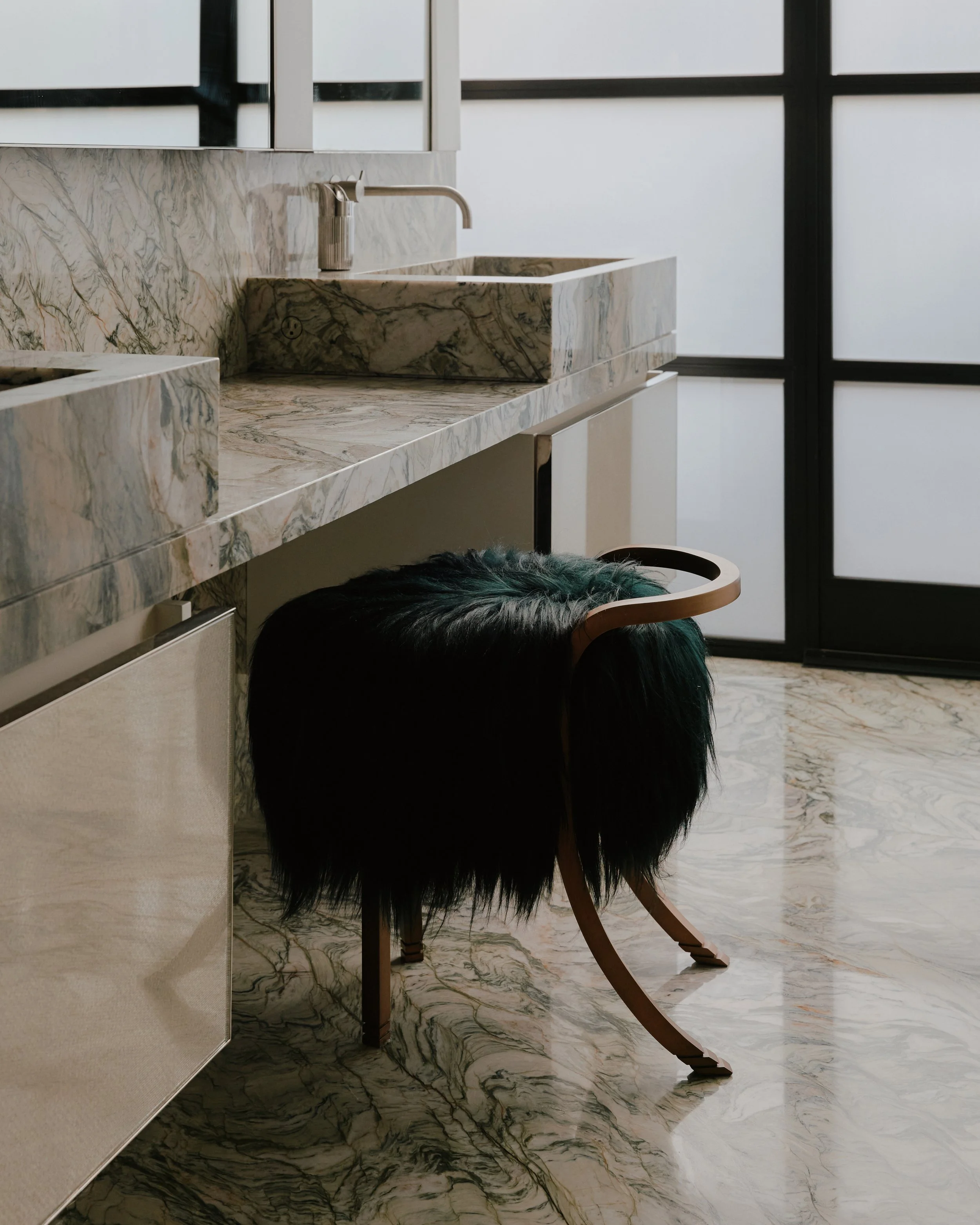 Bathroom with a veined marble vanity and stone sink in a West Village townhouse by JG Neukomm Architecture