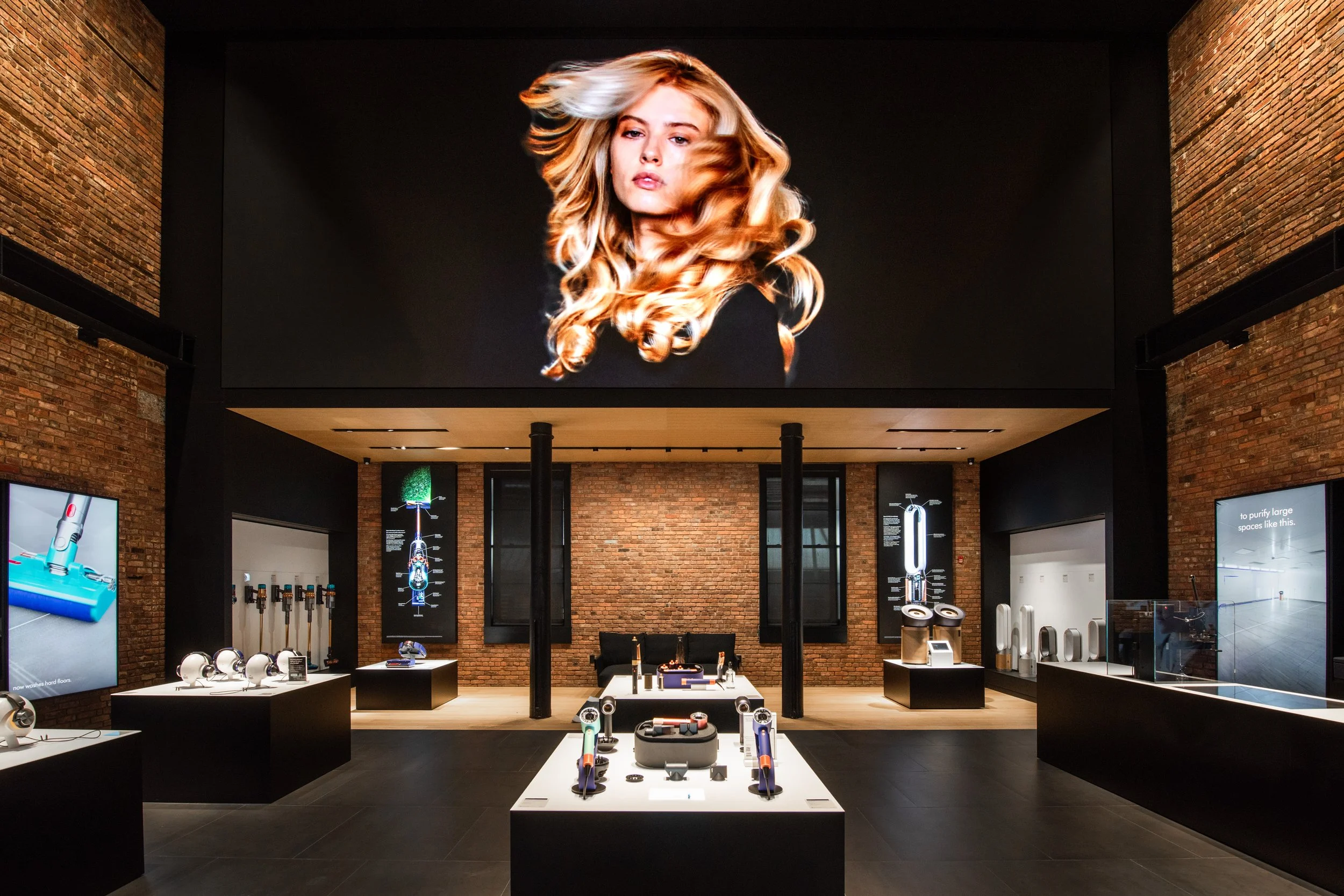 Dyson Demo Store large screen showing flowing styled hair above a brick demonstration area