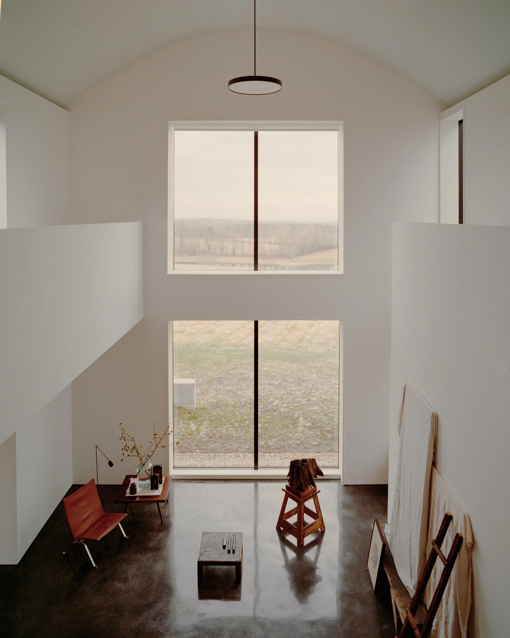 Barrel-vaulted double-height living room with stacked windows framing the countryside at a Ghent, NY home by JG Neukomm Architecture