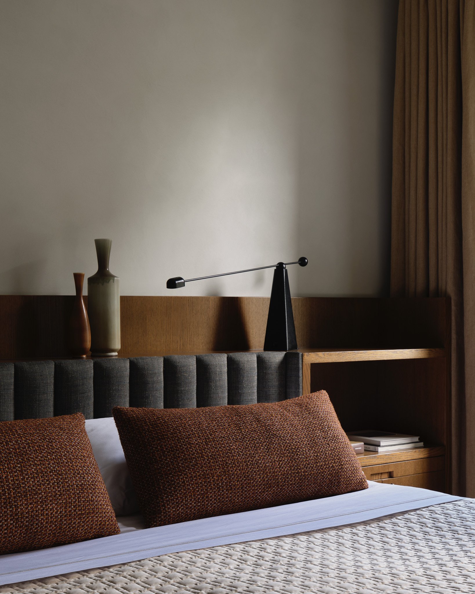 wooden bed frame with upholstered gray headboard and neutral bedding in a West Village townhouse by JG Neukomm Architecture