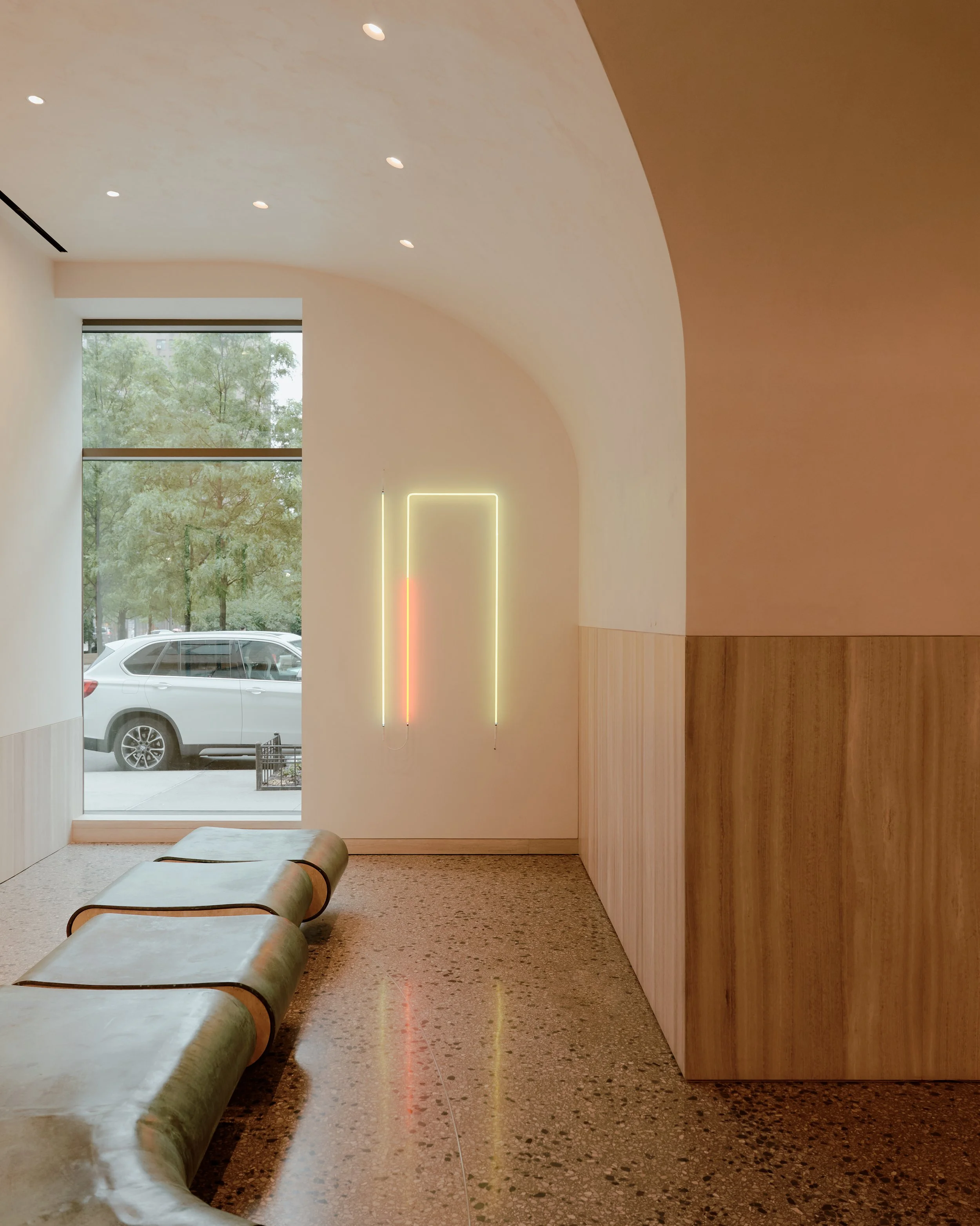 The Suffolk residential lobby designed by JGNA with vaulted arches, sculptural seating, floor-to-ceiling windows, and contemporary light installation