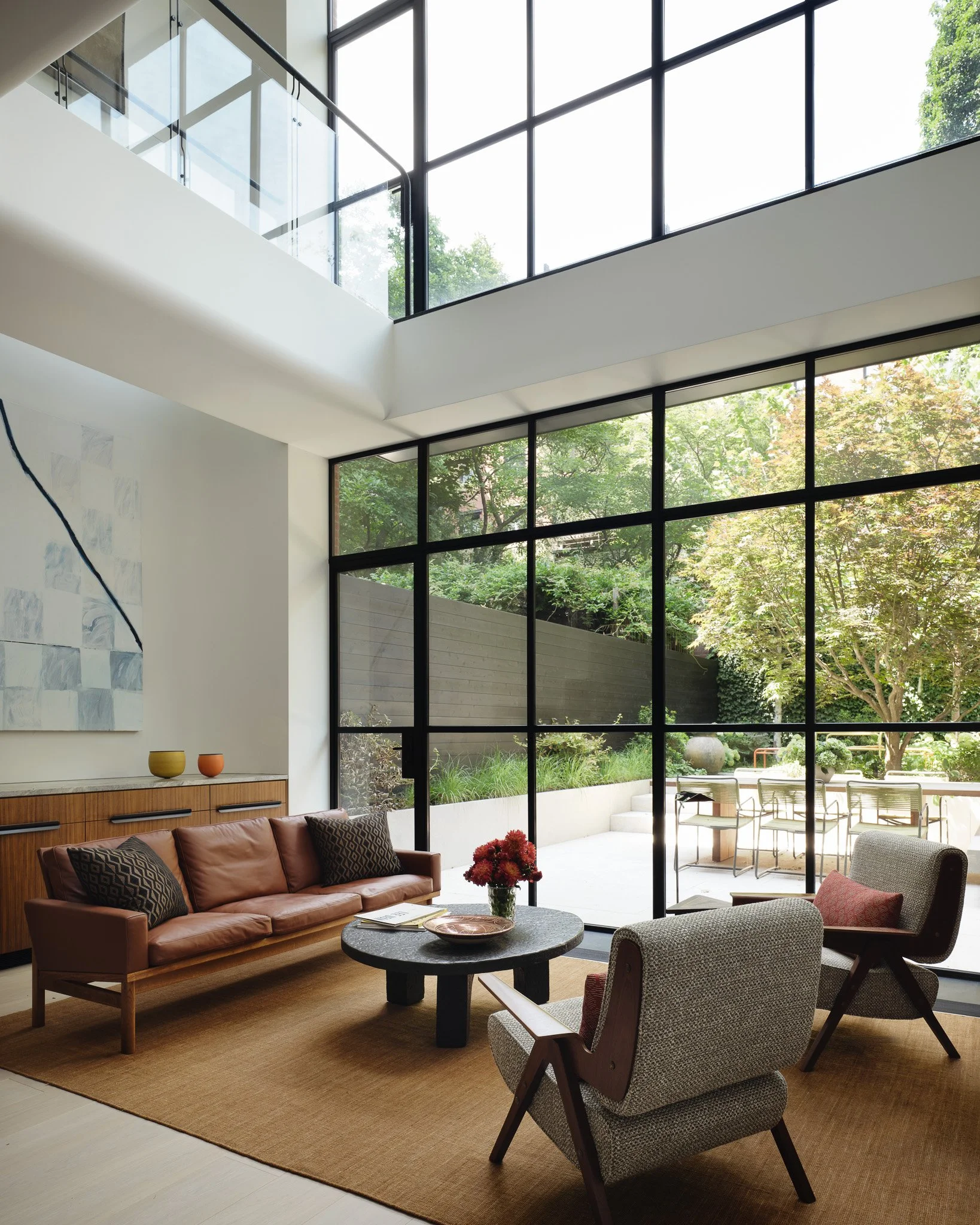 Double-height living room with a steel-framed garden window in a West Village townhouse by JG Neukomm Architecture