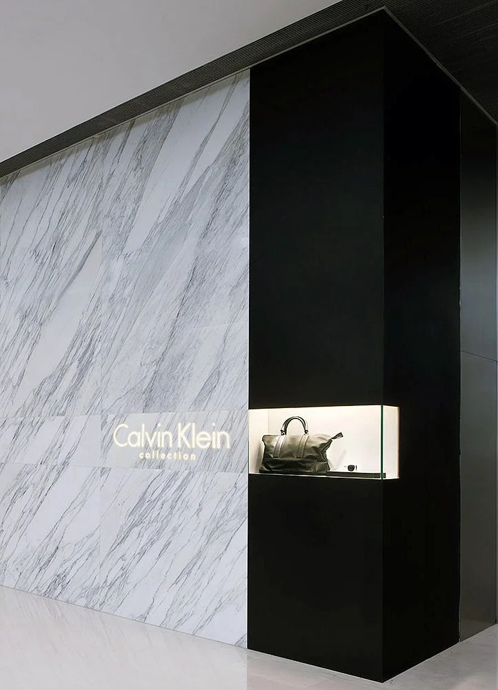Calvin Klein Collection marble wall with a recessed black display niche showing a leather bag