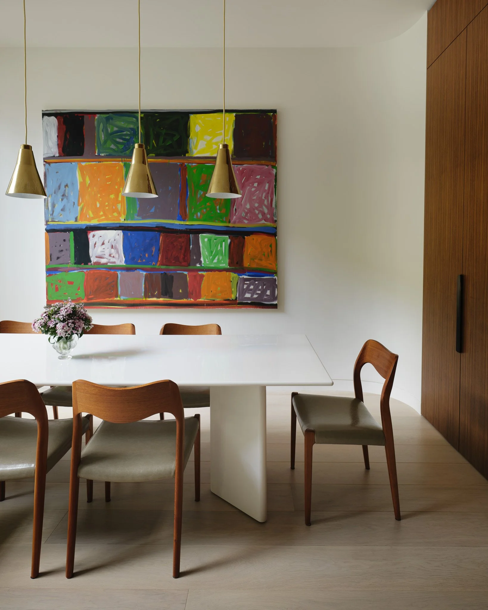 Dining area with mid-century chairs beneath a colorful grid painting in a West Village townhouse by JG Neukomm Architectur