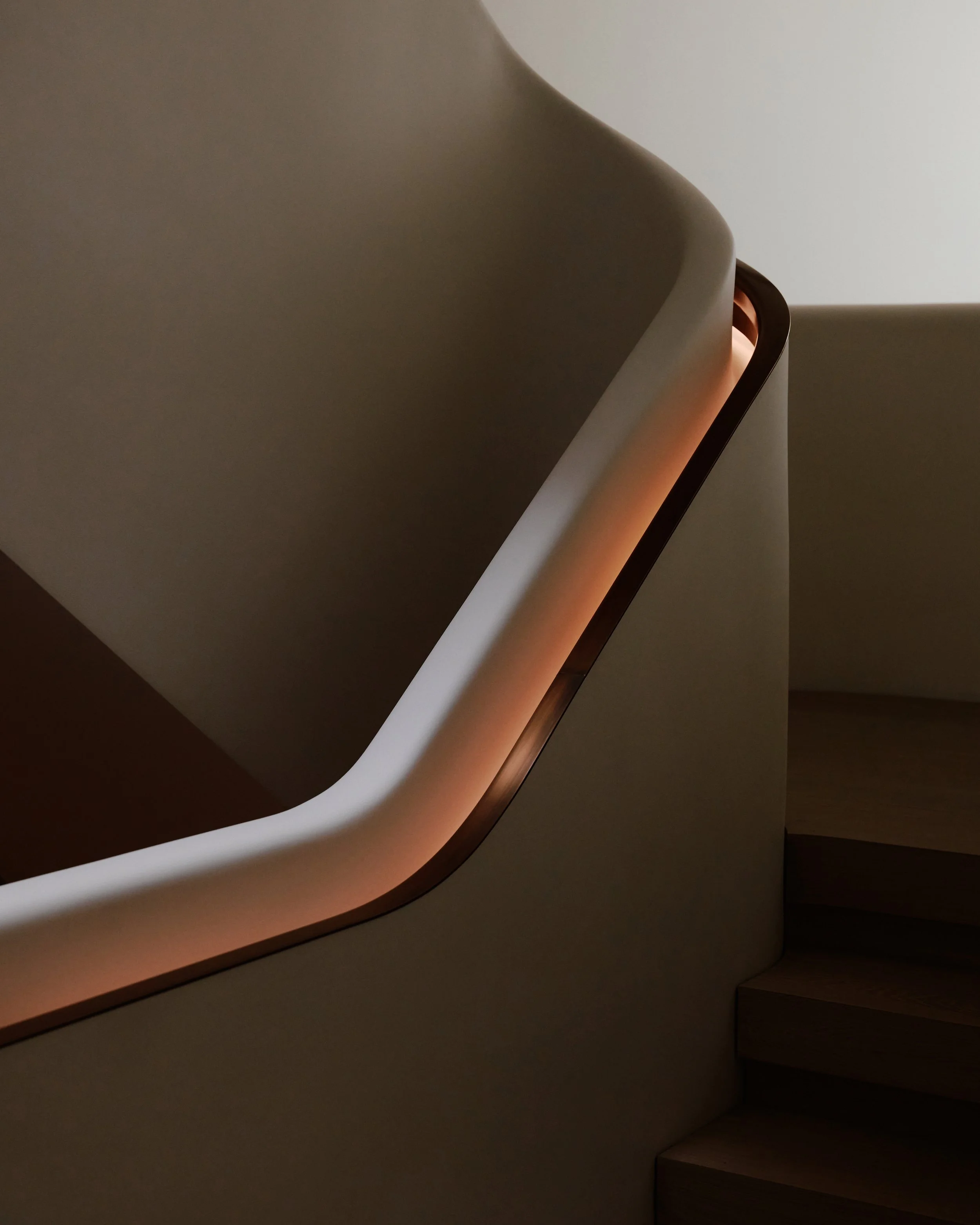 Copper recessed handrail along the sculptural white plaster staircase in a West Village townhouse by JG Neukomm Architecture