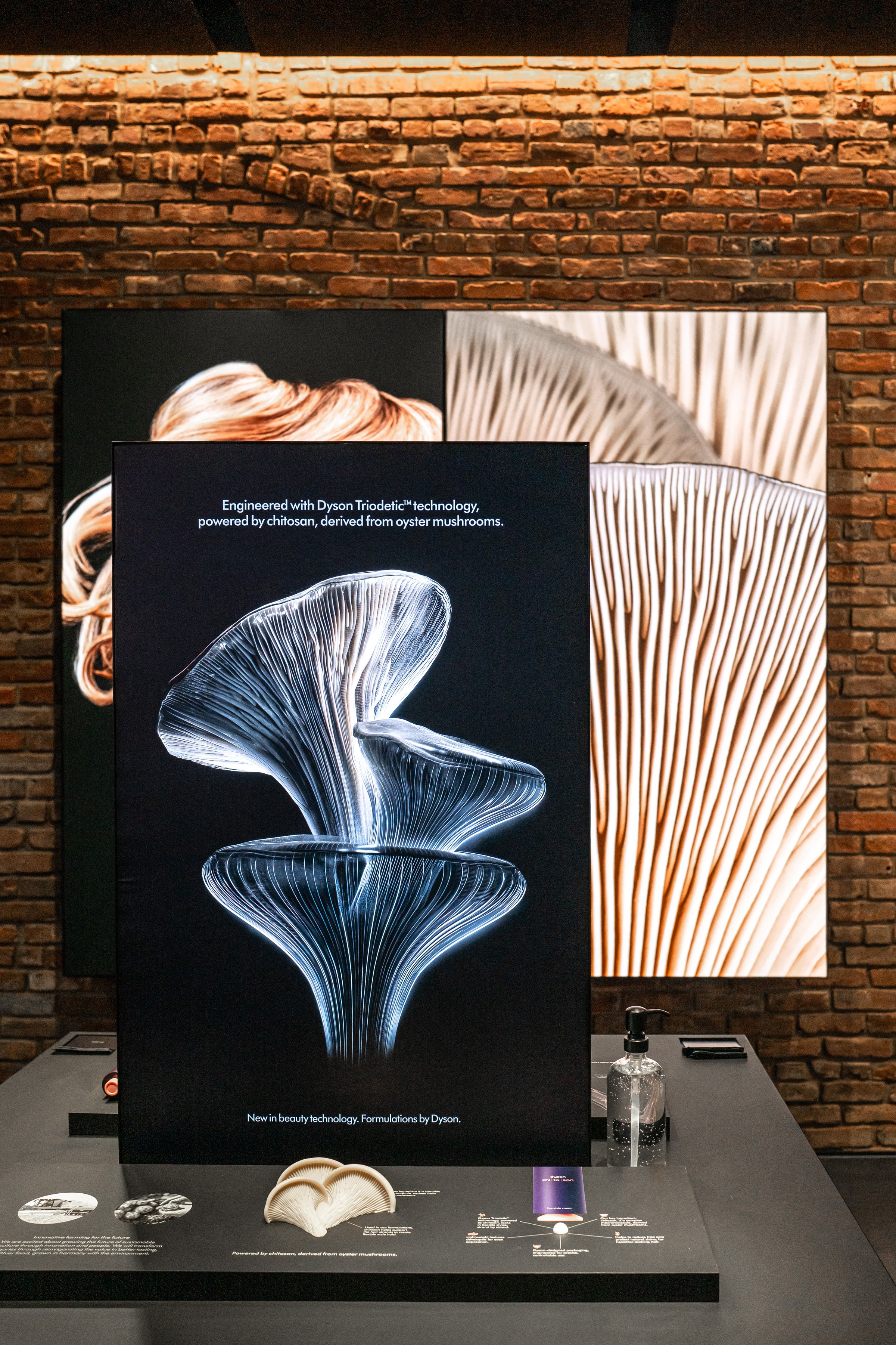 Dyson Demo Store black graphic display panel and product styling against an exposed brick wall