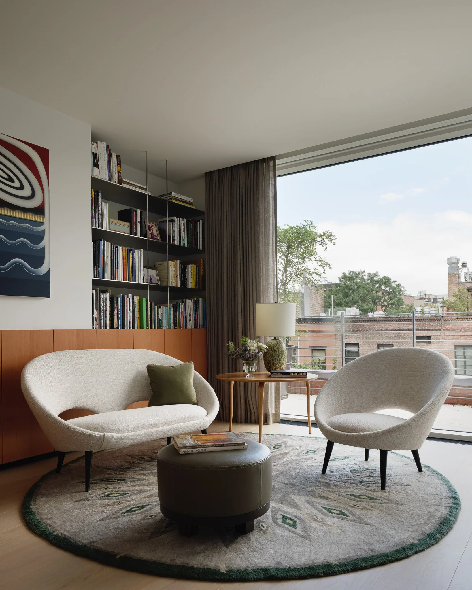 Library reading nook with built-in bookshelves and a pair of lounge chairs in a West Village townhouse by JG Neukomm Architecture
