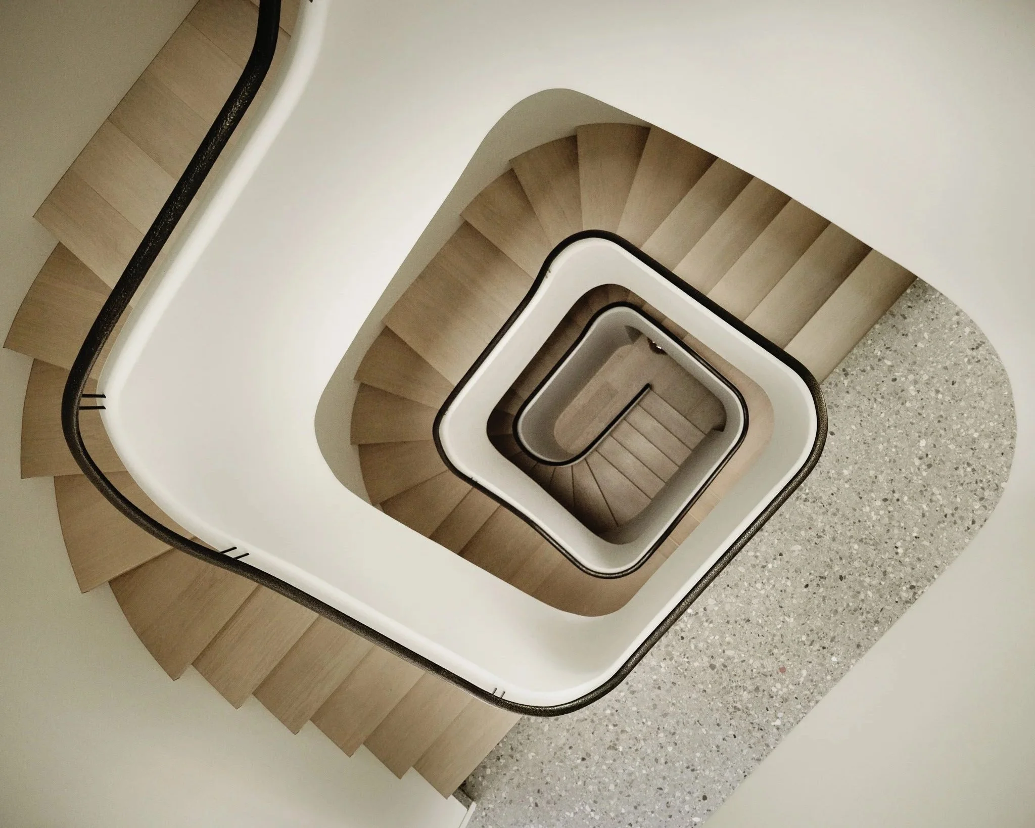 Overhead view of a spiraling oak staircase in a West Village townhouse by JG Neukomm Architecture
