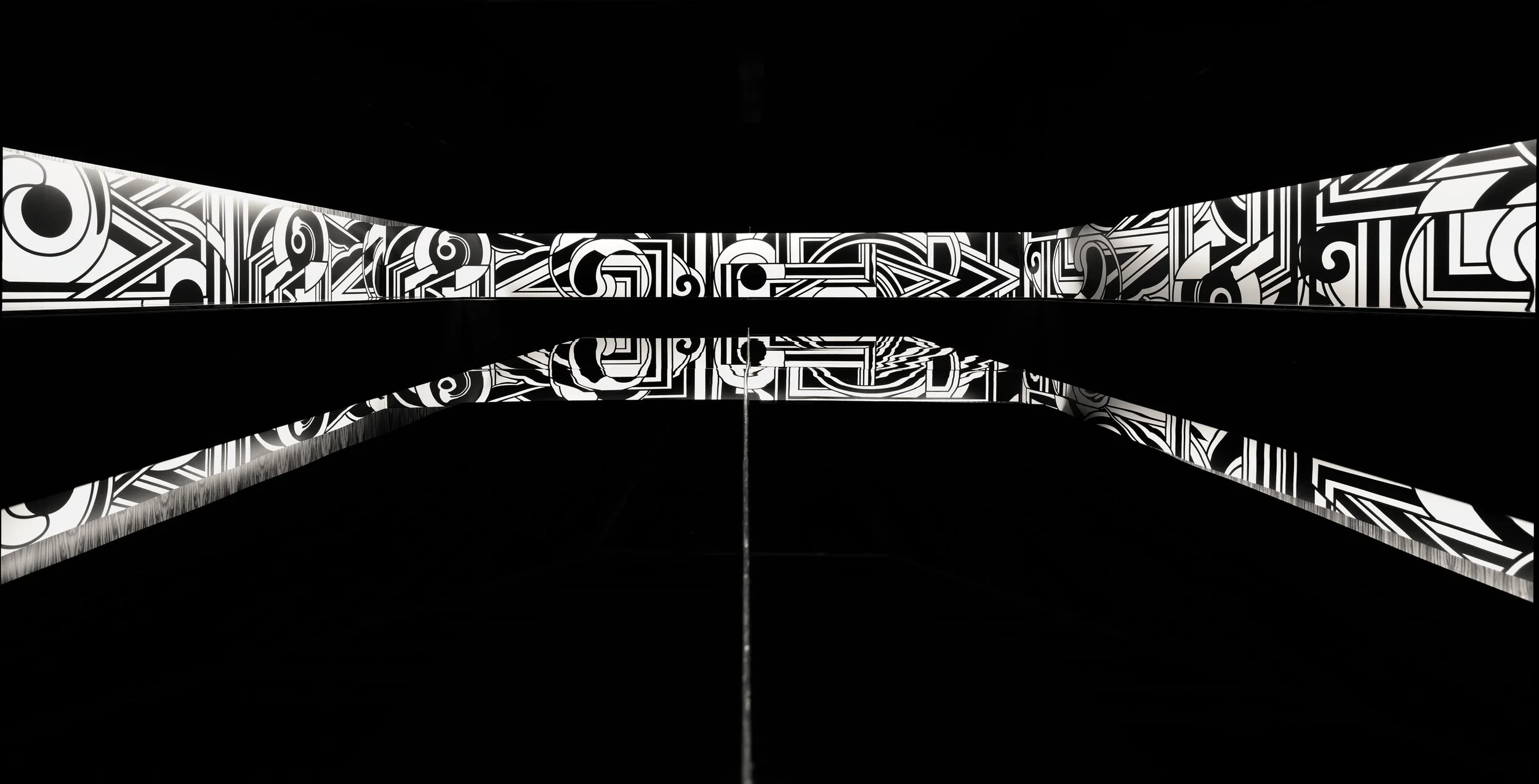 JGNA interior detail of a black-and-white graphic mural reflected in a mirrored ceiling