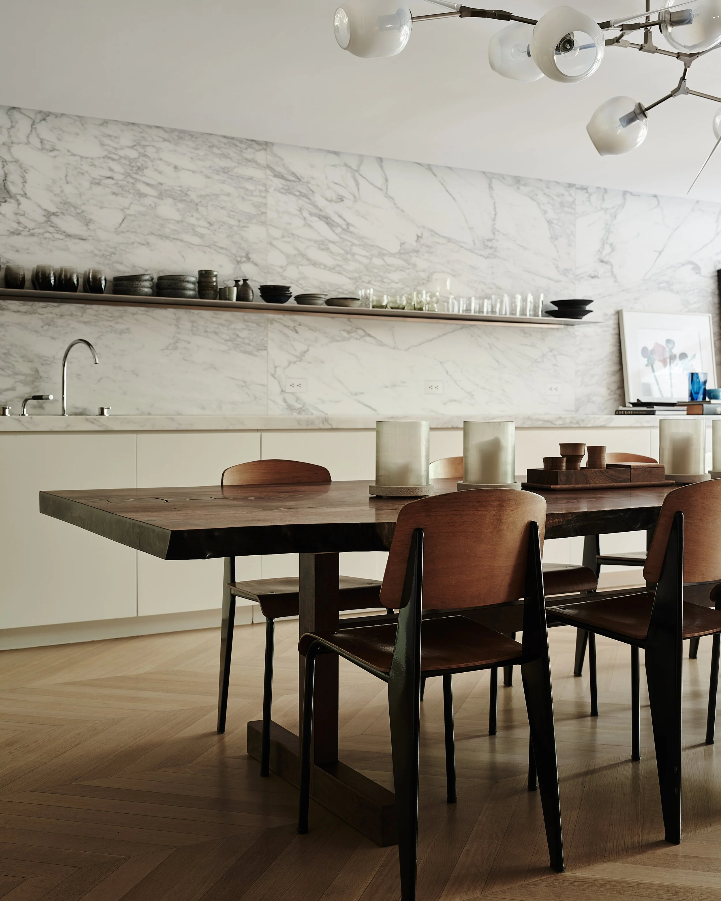 Marble slab backsplash kitchen with herringbone oak floors and dark wood dining table in Fabien Baron's West Village townhouse by JG Neukomm Architecture