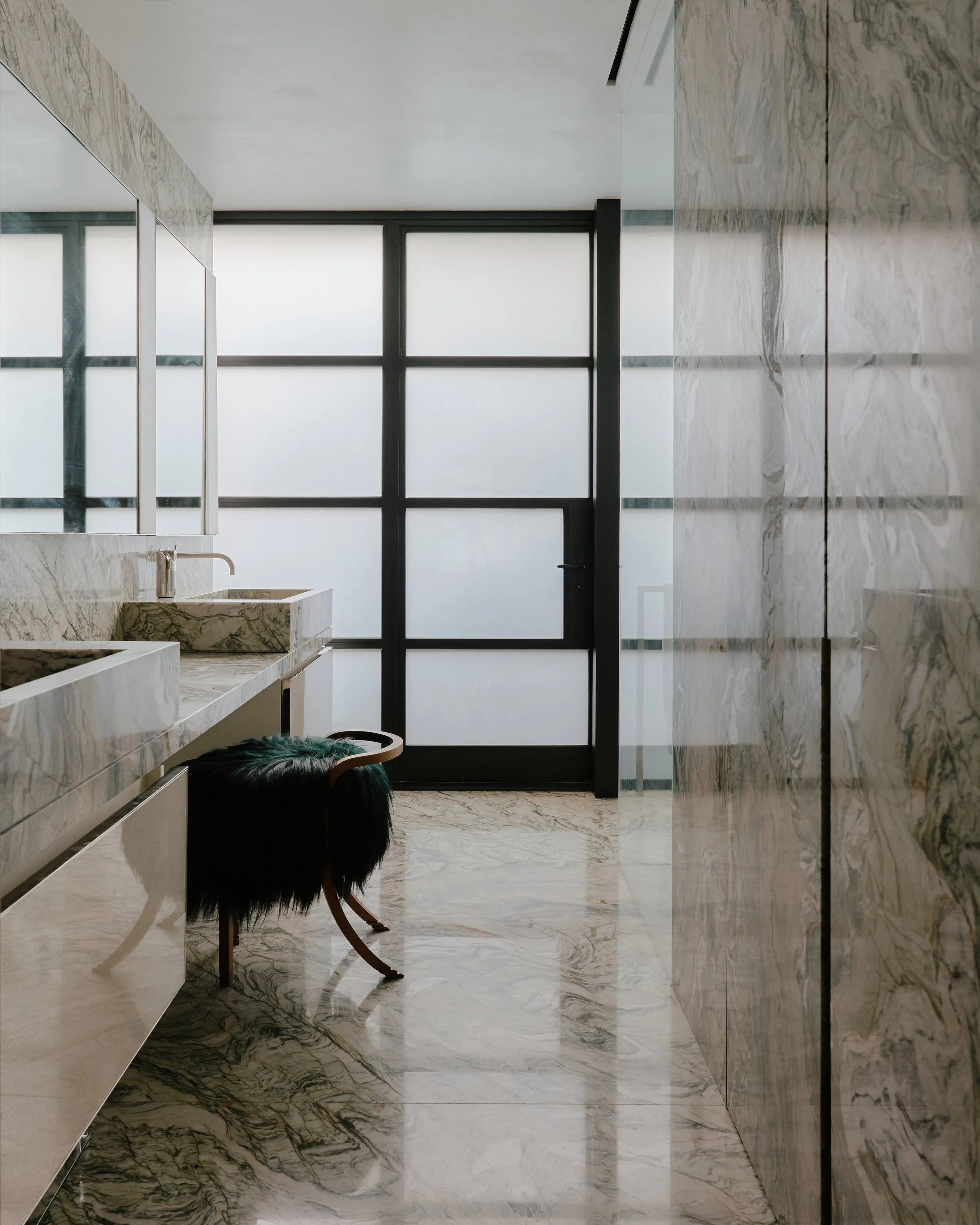 Bathroom with a veined marble vanity and stone sink in a West Village townhouse by JG Neukomm Architecture
