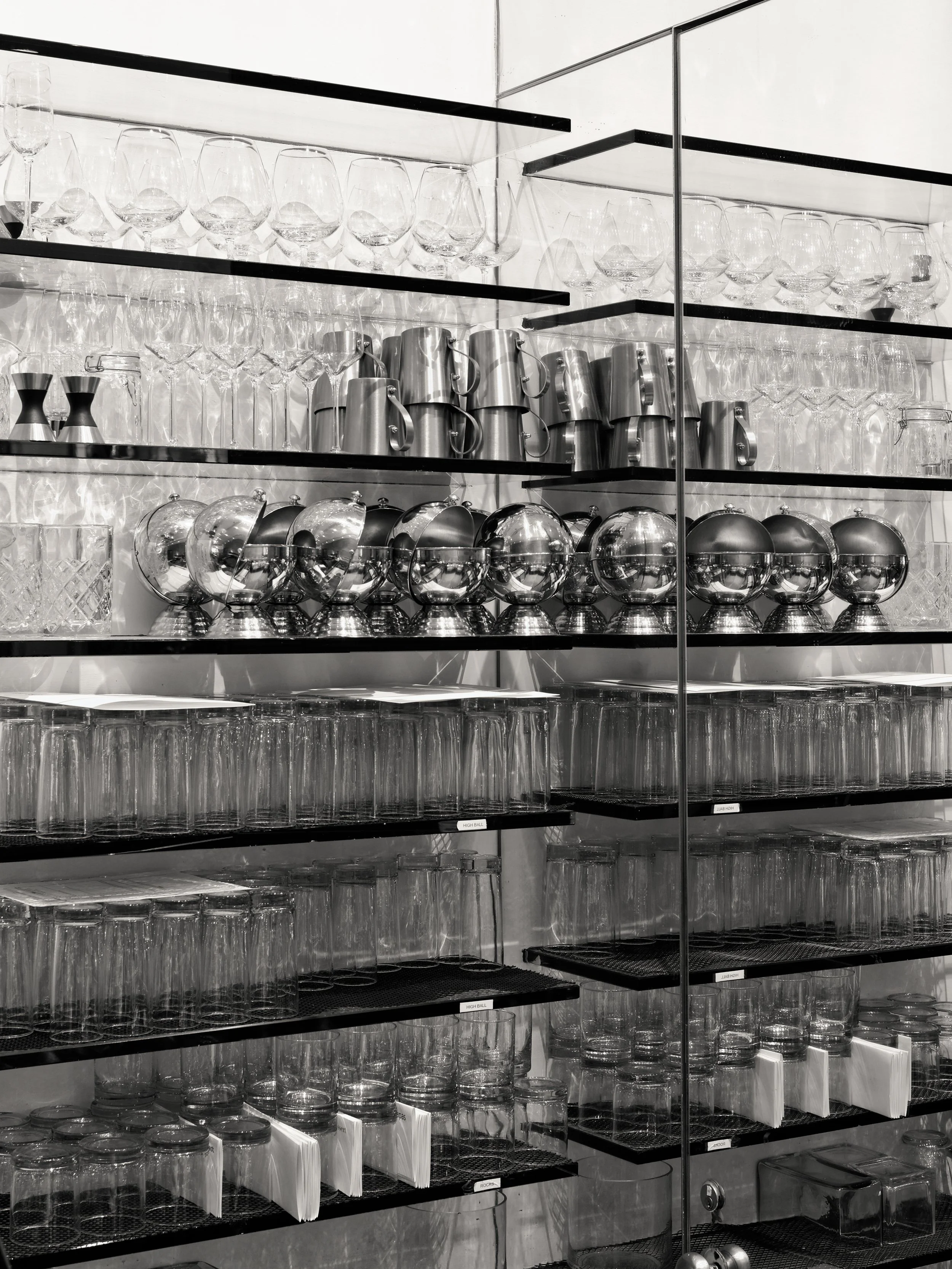 JGNA bar detail of glassware and silver barware arranged on illuminated display shelving