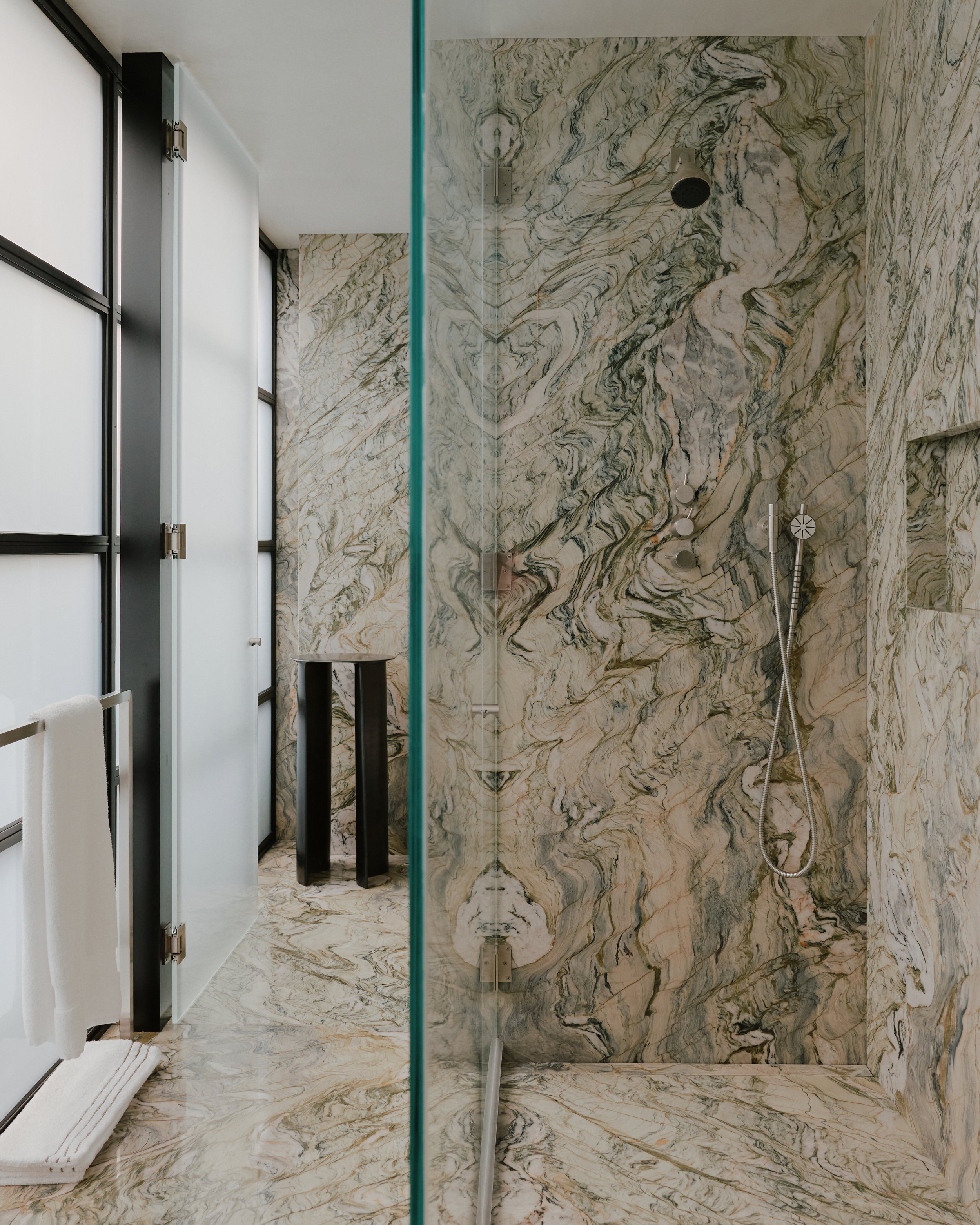 Marble shower with a glass enclosure in a West Village townhouse by JG Neukomm Architecture