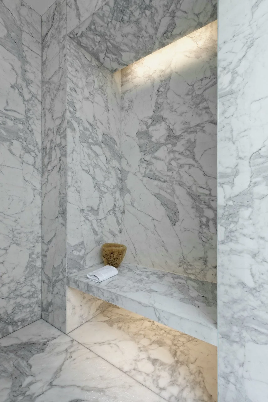 Floor-to-ceiling Carrara marble steam shower with built-in bench and recessed lighting in Fabien Baron's West Village townhouse by JG Neukomm Architecture