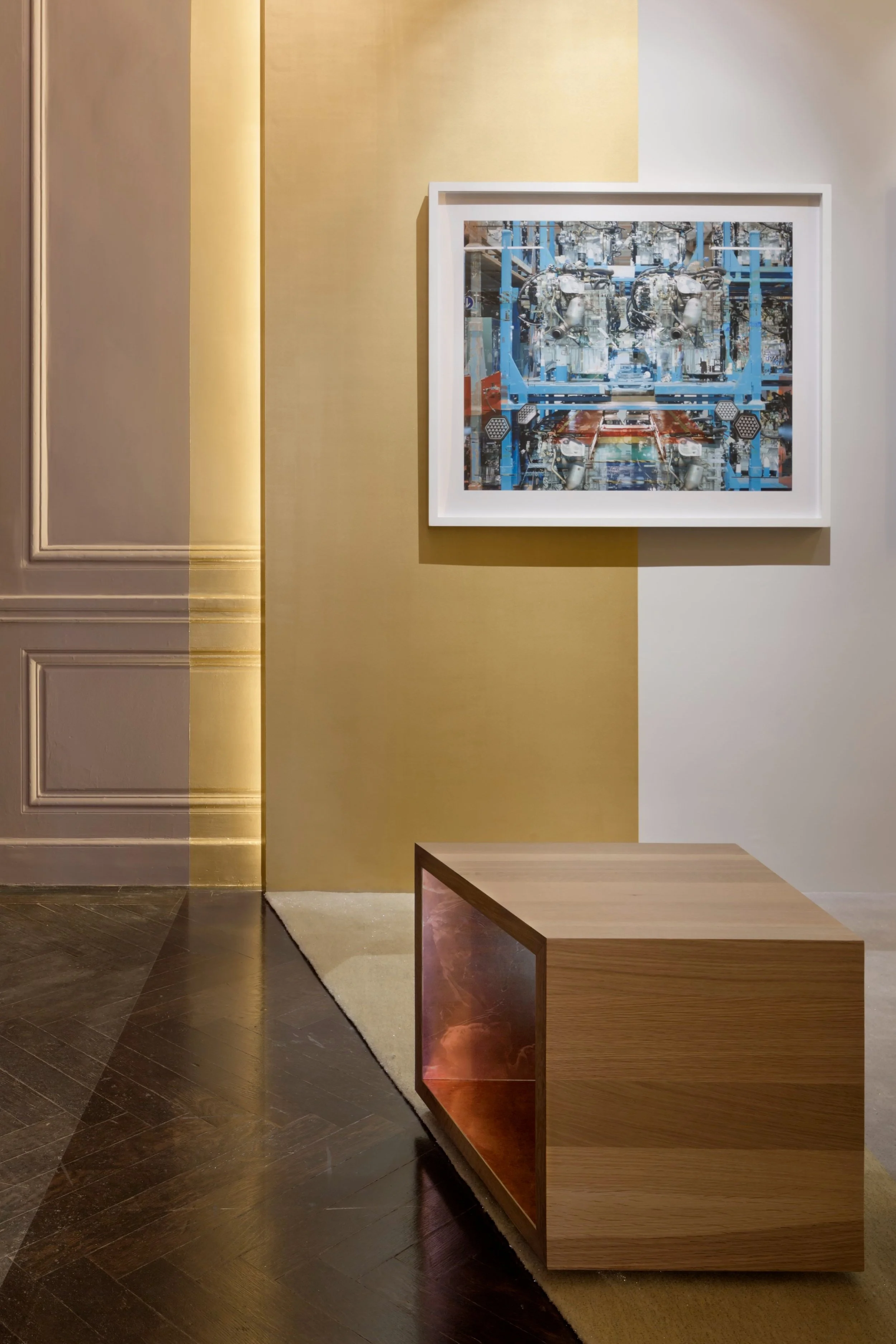 JGNA gallery wall detail with a framed photograph above an oak and copper-lined console on dark stone flooring