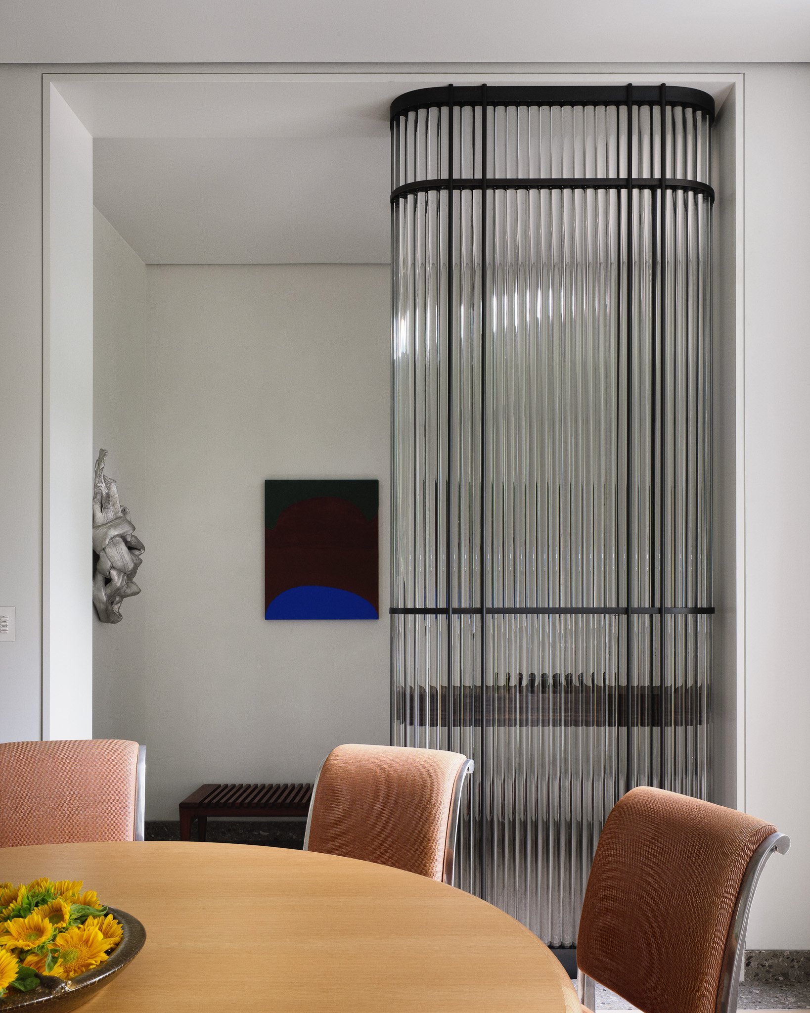 modern dining area with fluted-glass partition and round oak table in townhouse by JG Neukomm Architecture