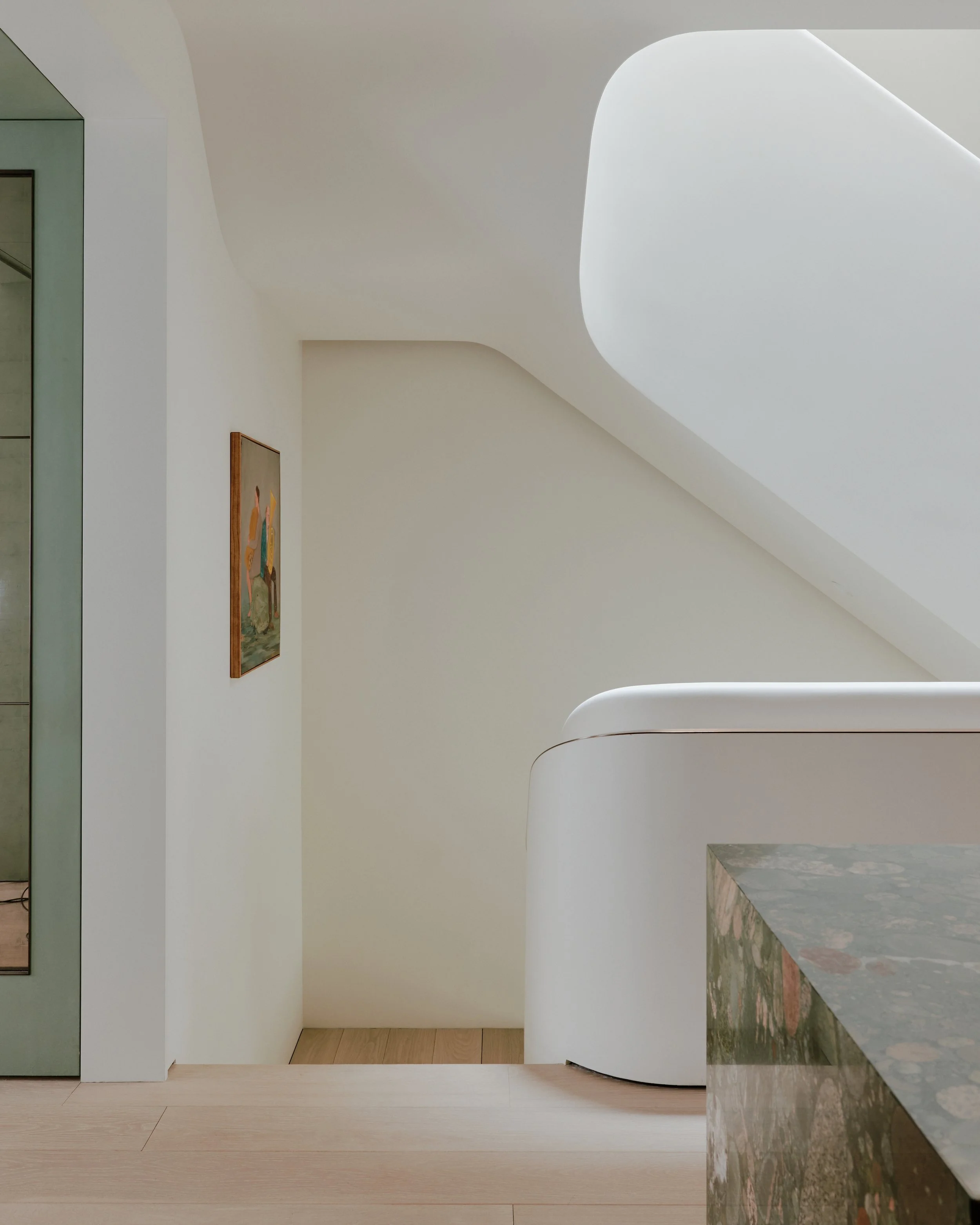 Sculptural white plaster staircase viewed from a landing with contemporary art in a West Village townhouse by JG Neukomm Architecture