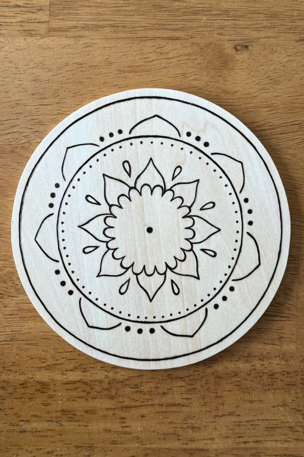 Hand-burned mandala artwork “Still” by Cheyenne Wenske, pyrography on birch panel.