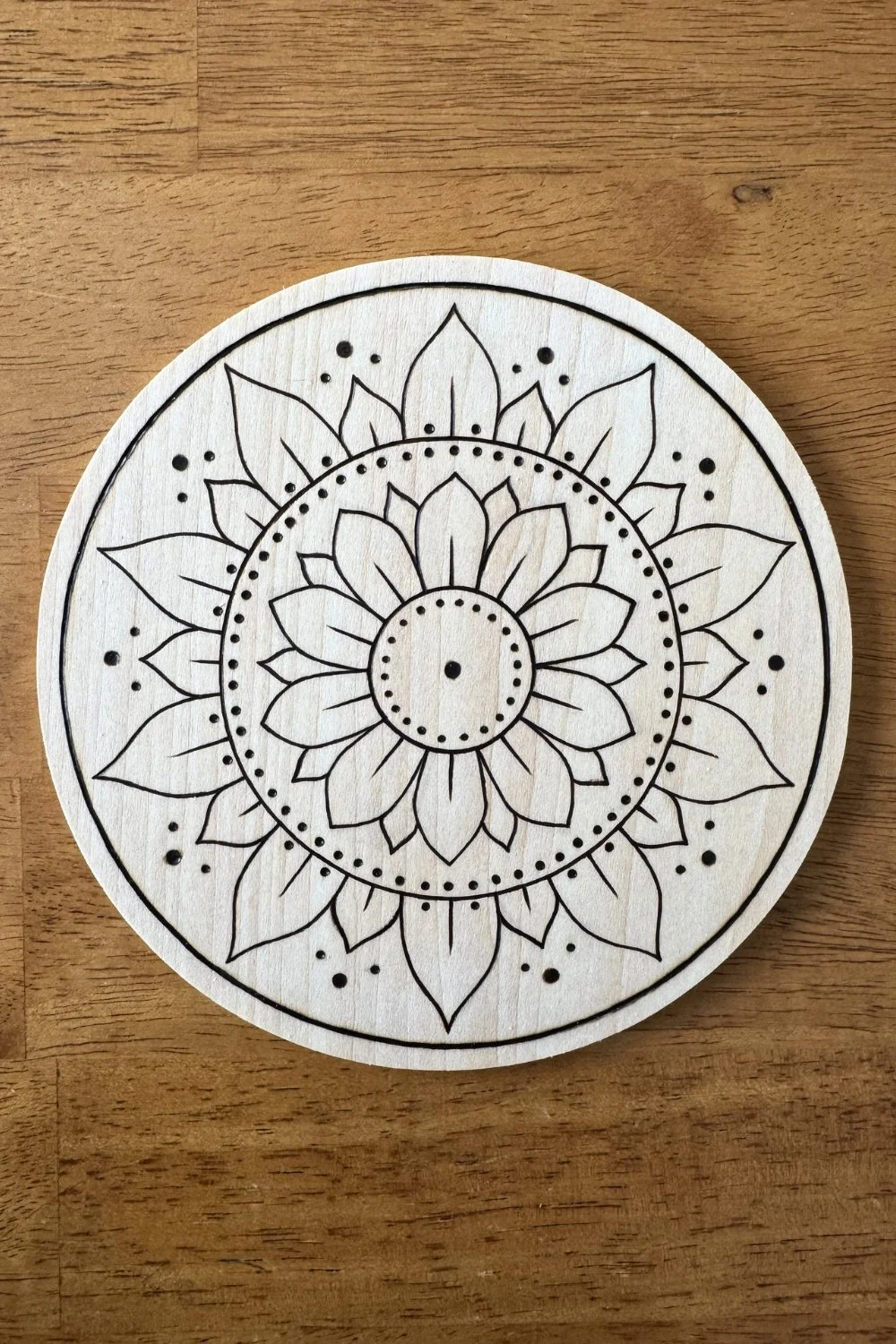 Hand-burned mandala artwork “Opening” by Cheyenne Wenske, pyrography on birch panel.