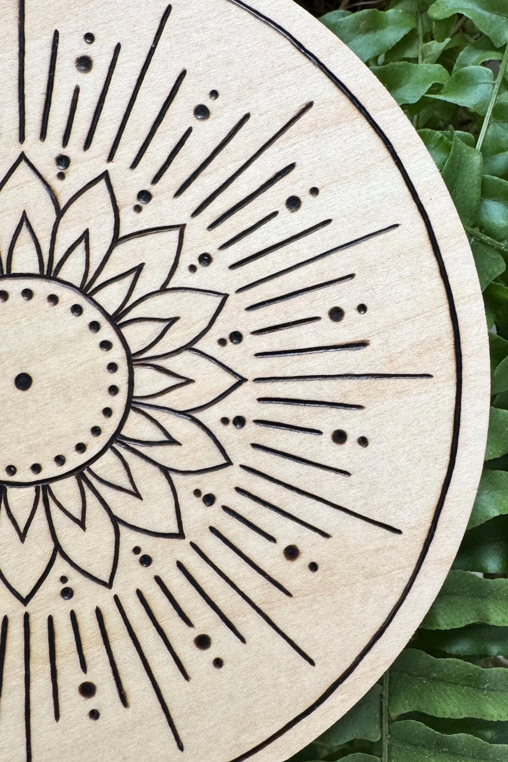 Hand-burned mandala artwork “Radiant” by Cheyenne Wenske, pyrography on birch panel.