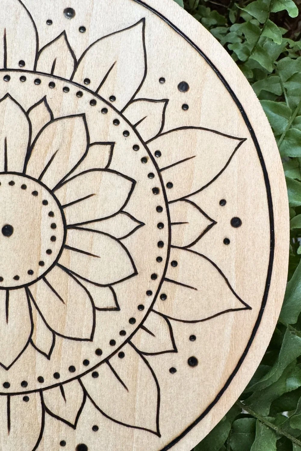 Hand-burned mandala artwork “Opening” by Cheyenne Wenske, pyrography on birch panel.