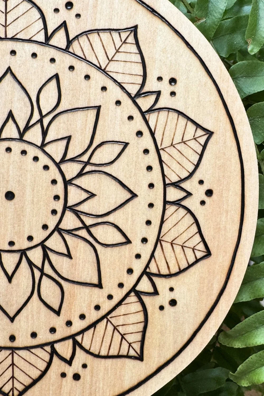 Hand-burned mandala artwork “Return” by Cheyenne Wenske, pyrography on birch panel.