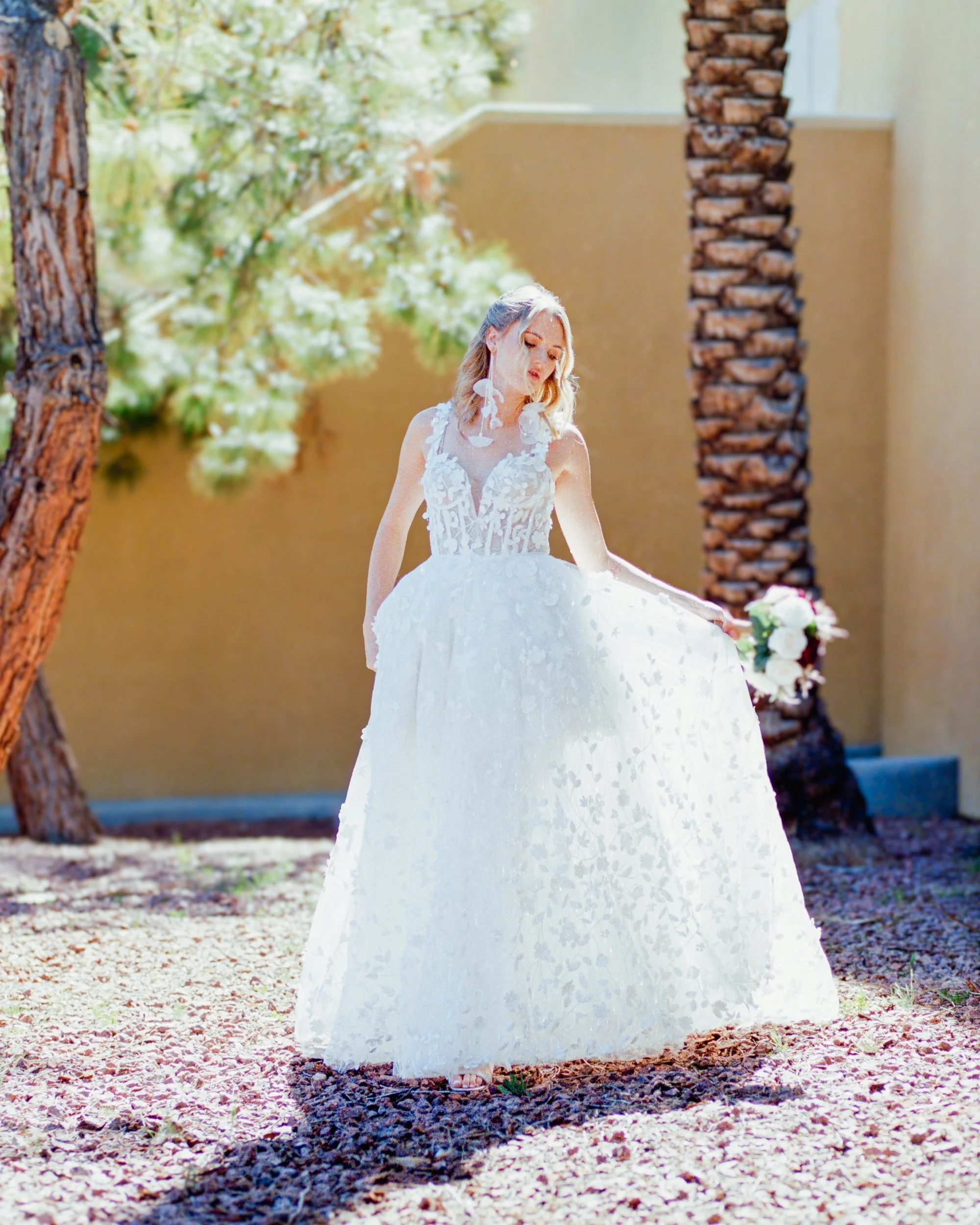 Bride looking over shoulder walking away in wedding dress with red and white bouquet Bridal portrait session photographed on Kodak Portra 400 film by ParksPictures