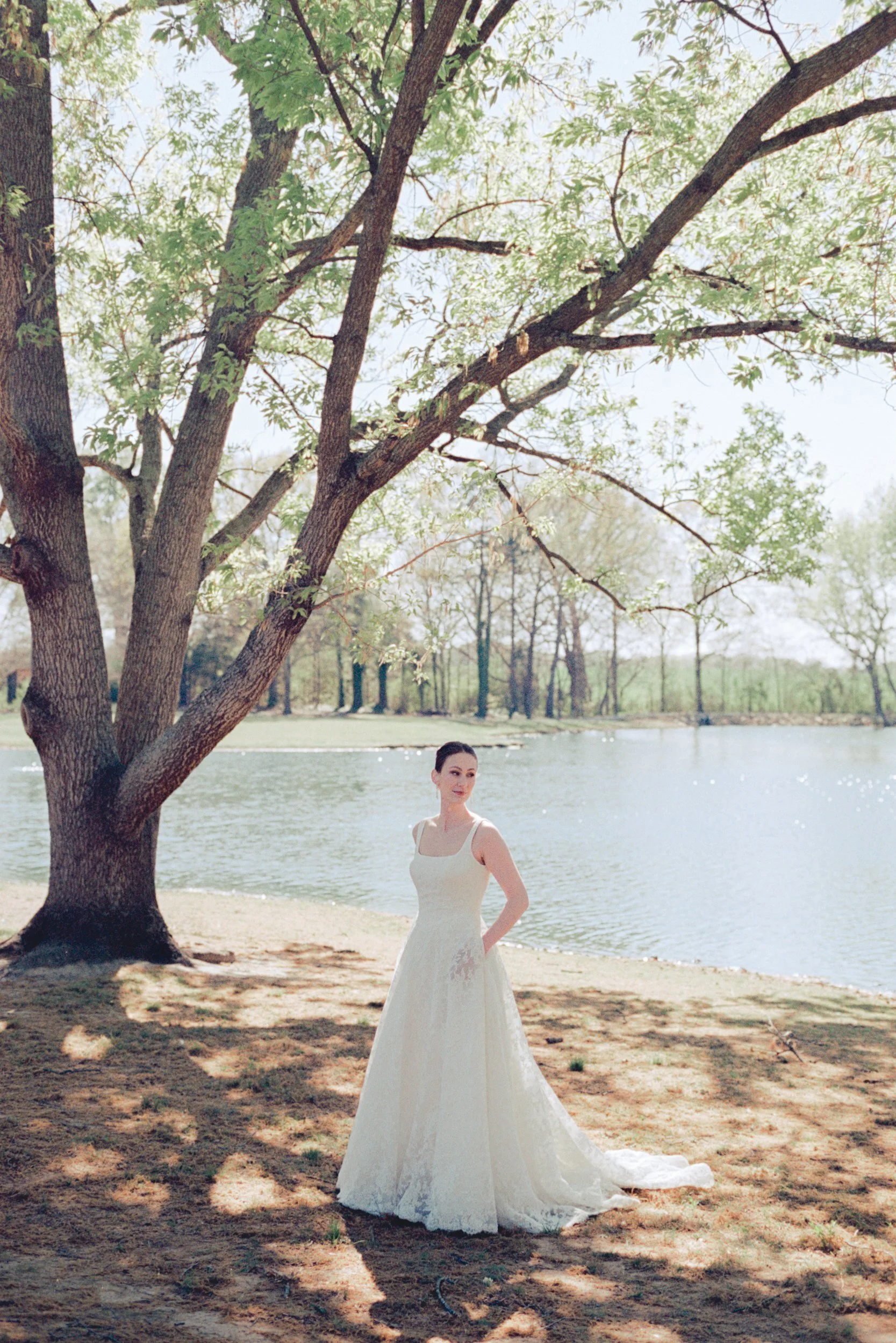 Editorial Film Wedding Photo at the Union Exchange by Charlotte wedding photoas her groom admires her other at sunset overlooking Uptown Charlotte skyline on rooftop of Kingston South End by Charlotte wedding photographer Michael Parks, ParksPictures