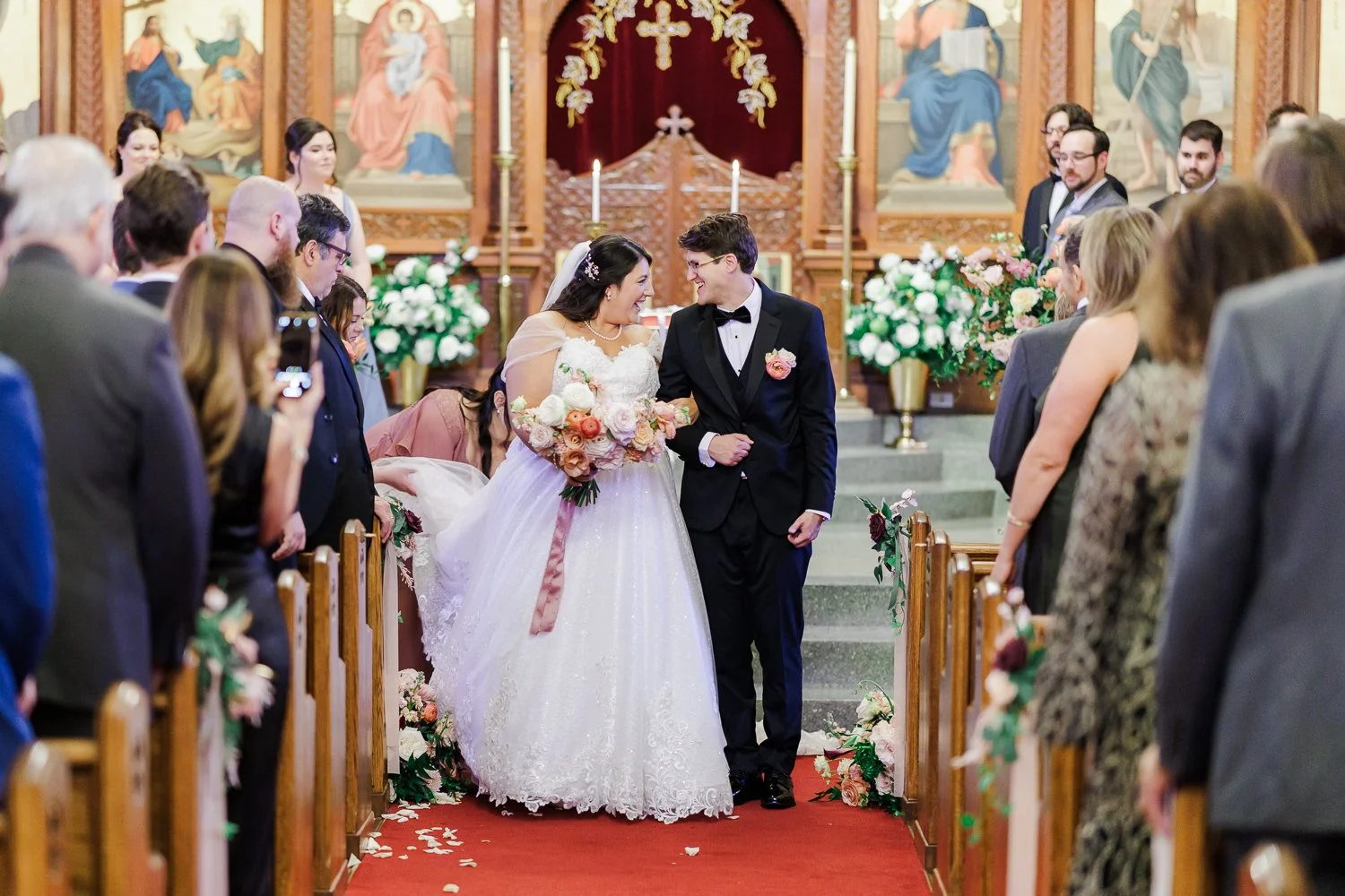 Bride and Groom walking down aisle and smiling at each other after Greek Orthodox at Holy Trinity Cathedral in Dilworth Charlotte NC