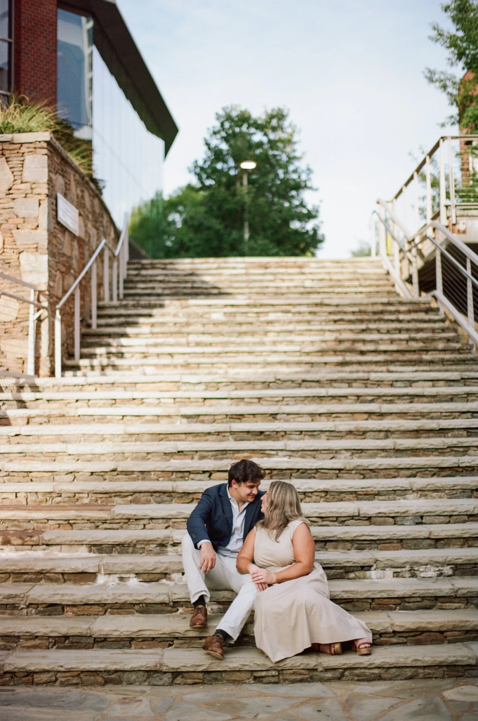 Boyfriend proposing on one knee to girlfriend in front of waterfall at Falls Park in Greenville SC, by ParksPictures